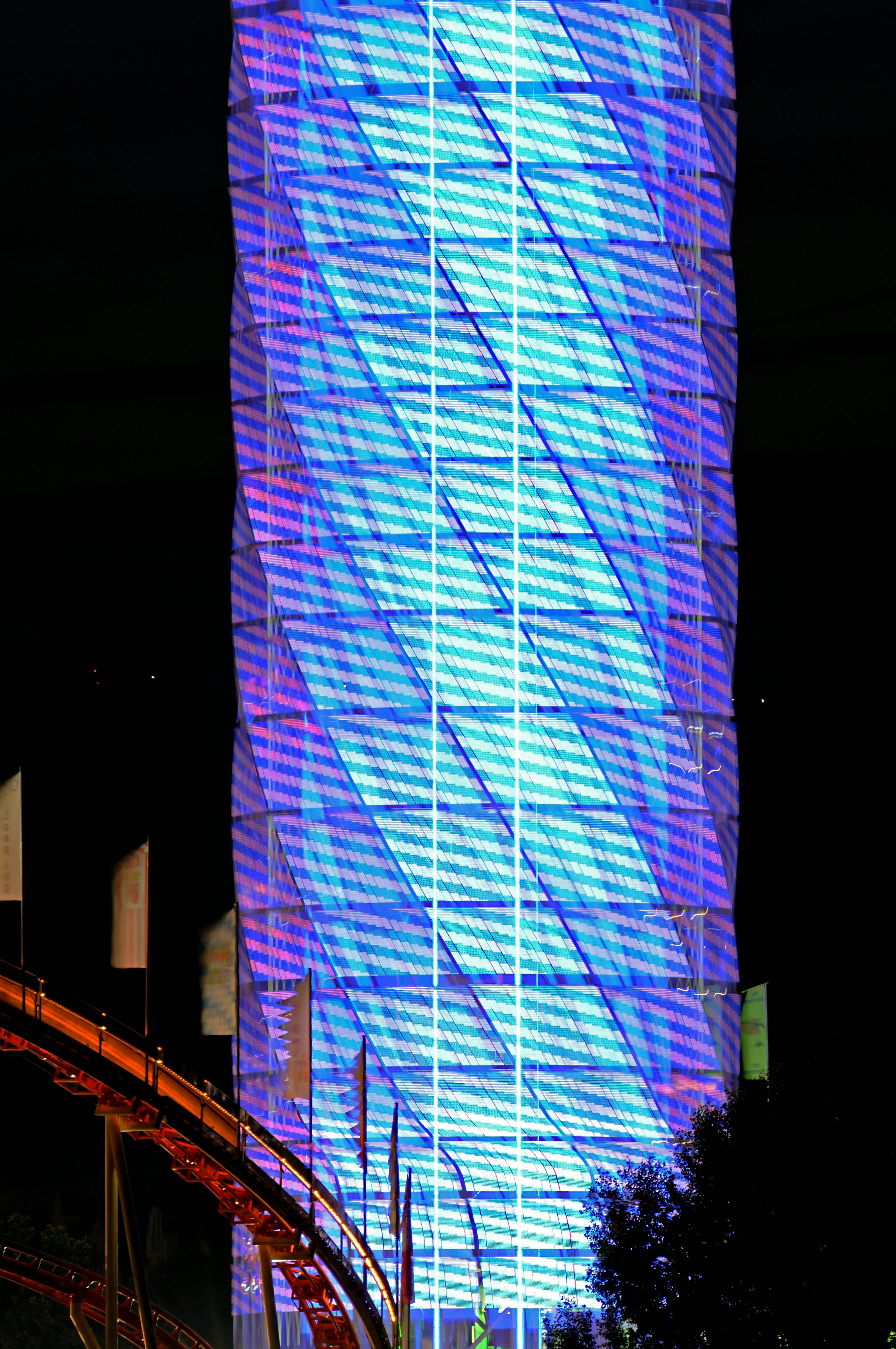 Imagen de una torre alta iluminada con luces azules por la noche