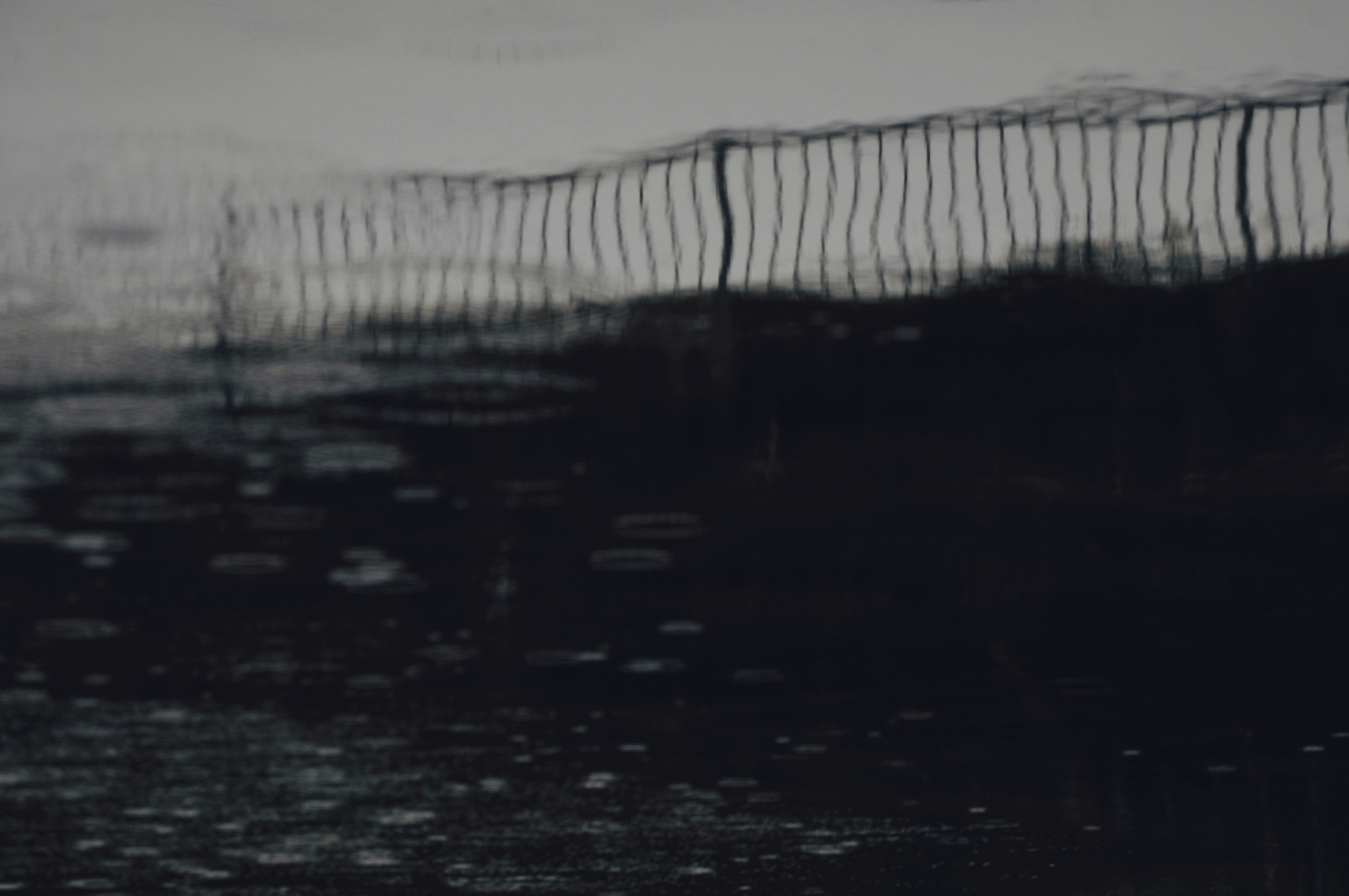 Reflection of a fence on the water surface