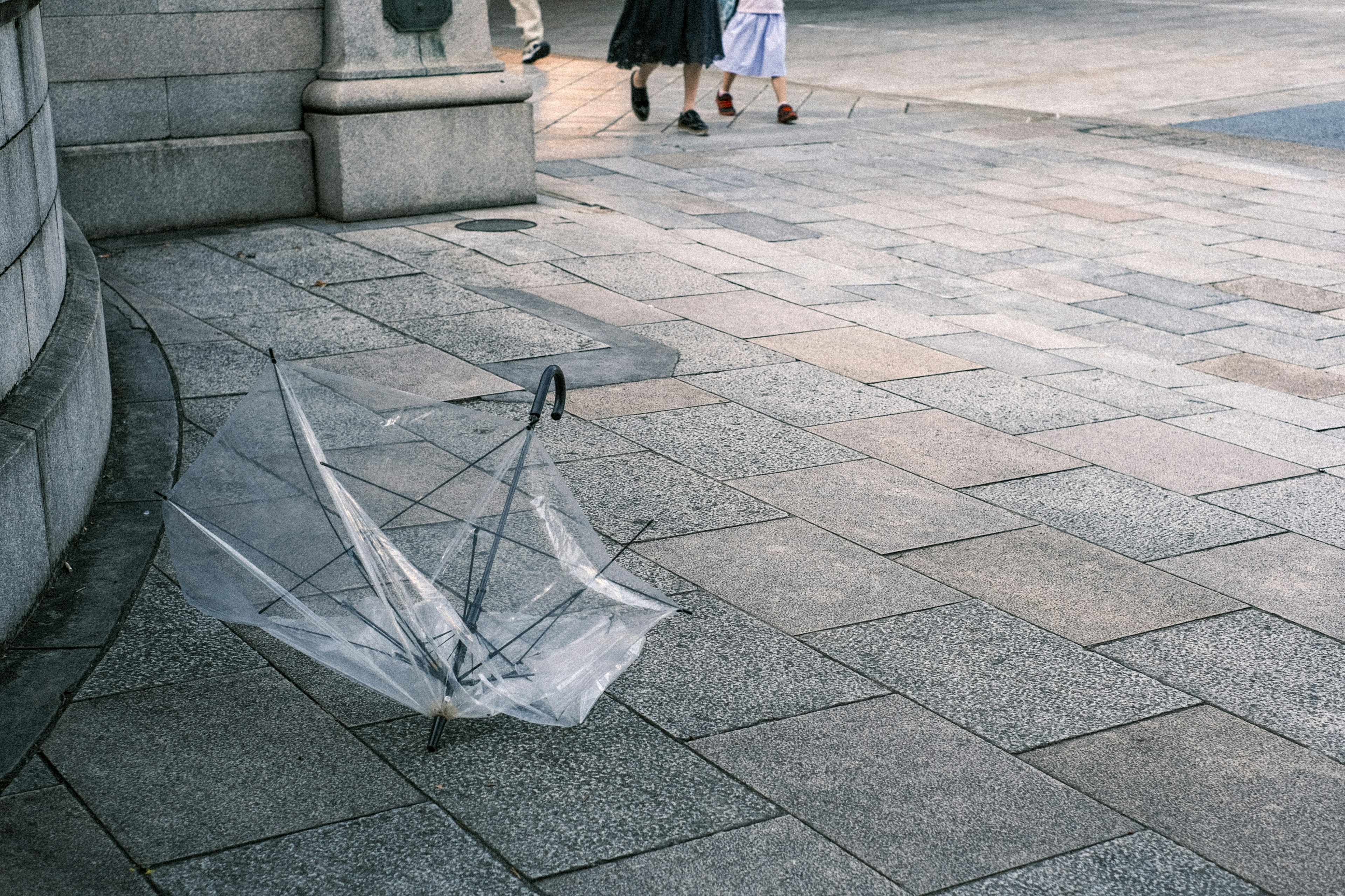 Un parapluie cassé sur le trottoir