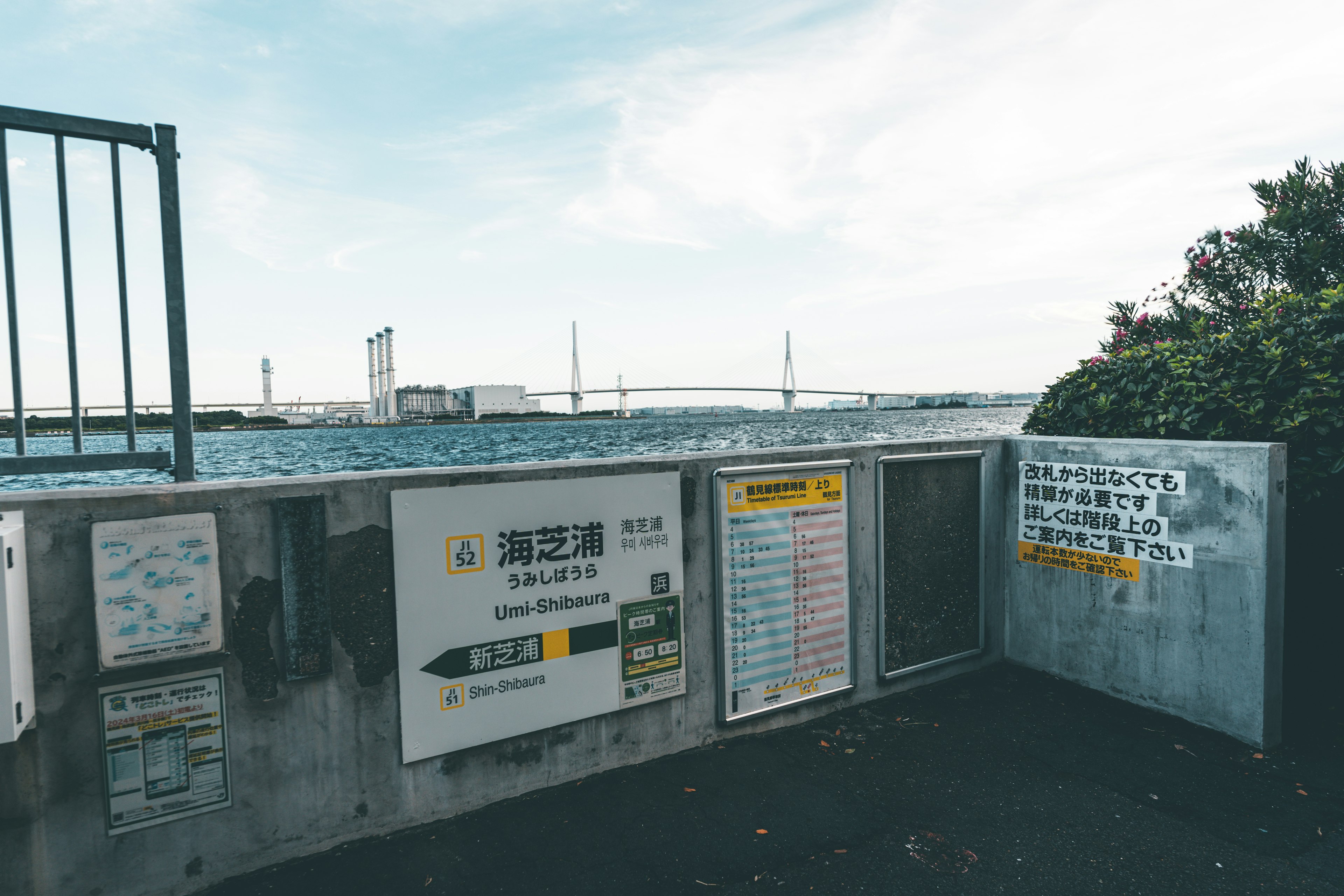 海沿いの公園にある案内板と橋の眺め