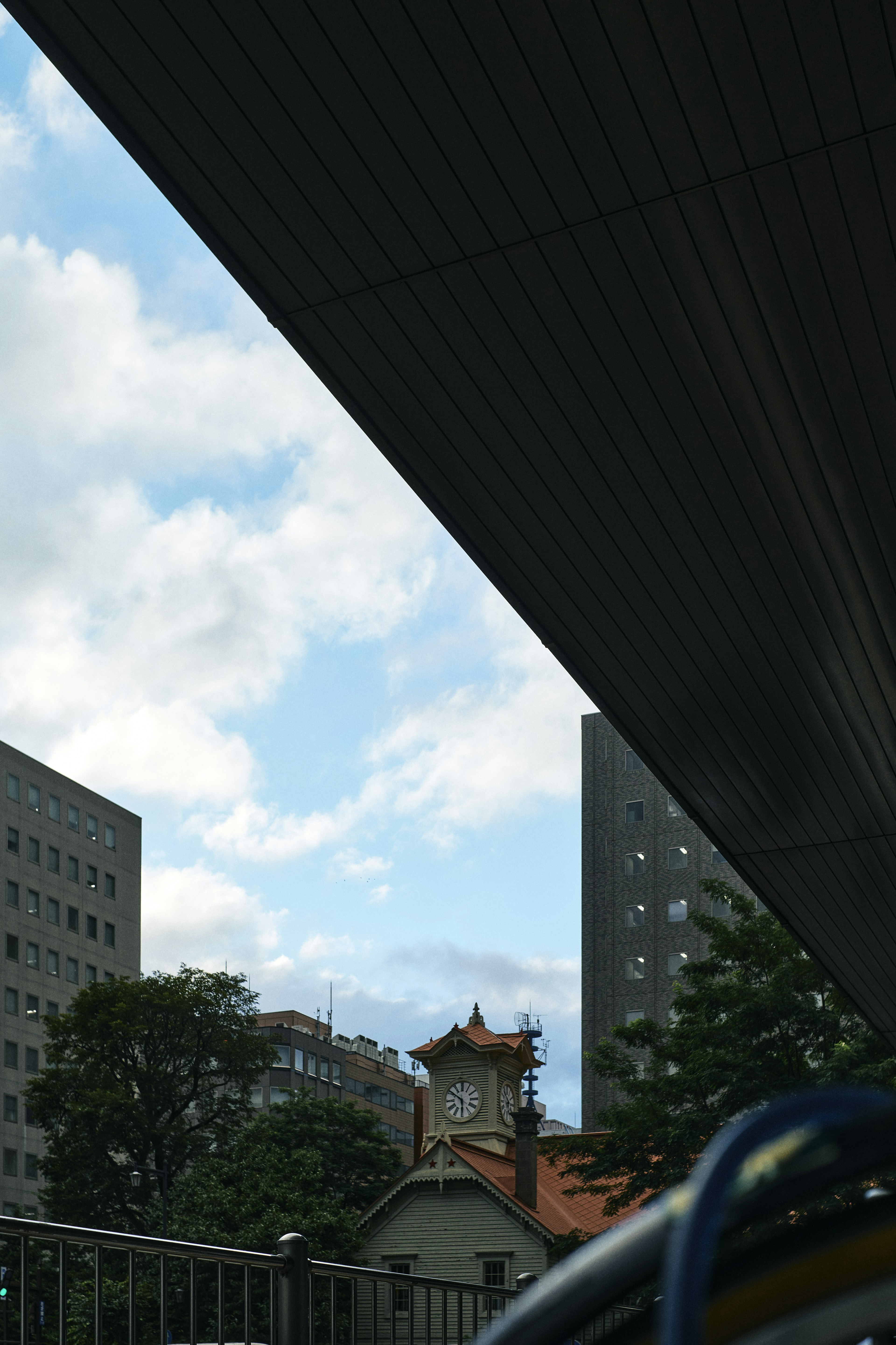 Städtische Landschaft mit Gebäuden und einer historischen Struktur unter blauem Himmel