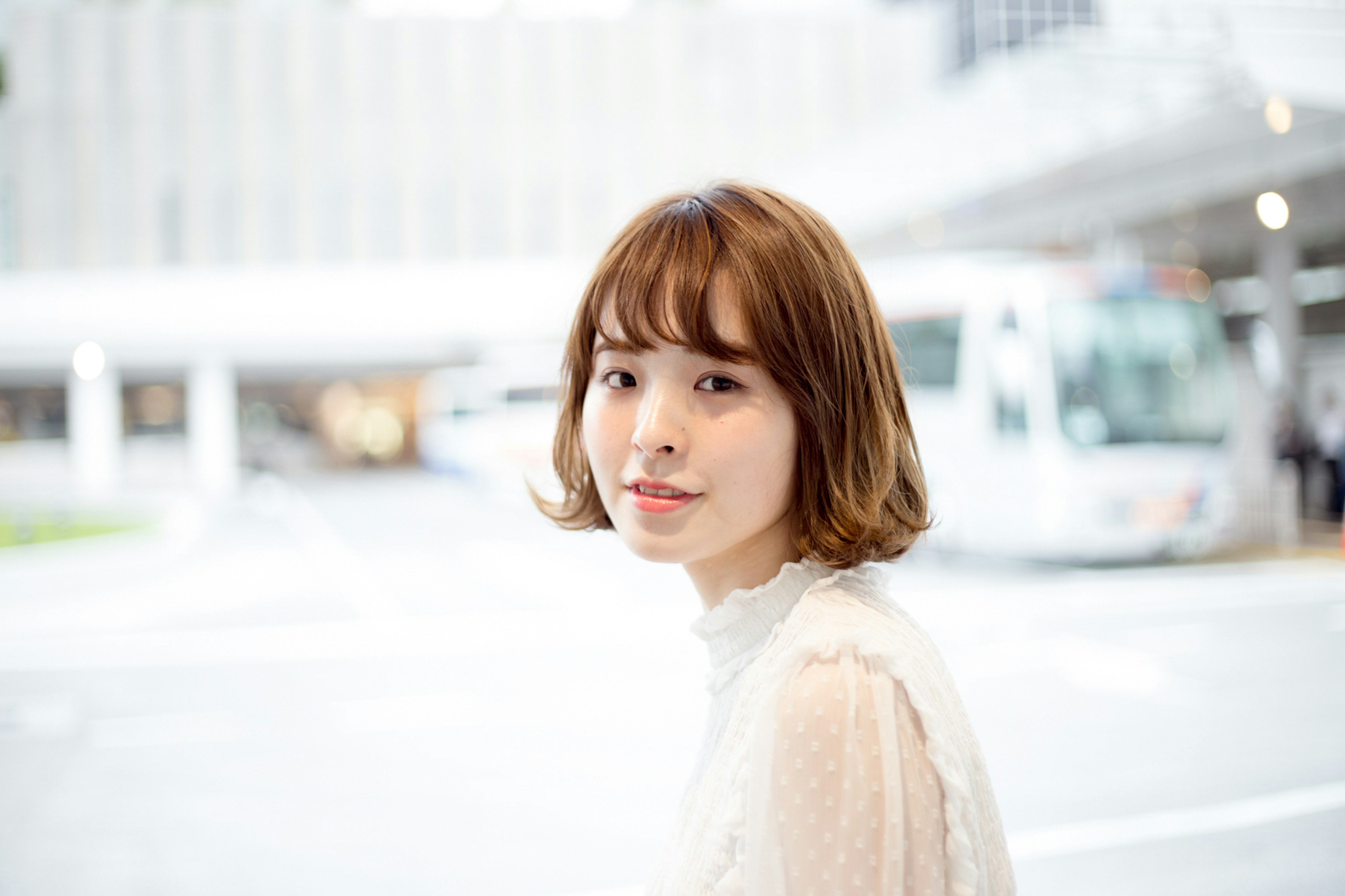 Young woman looking back in the city background with buses and buildings