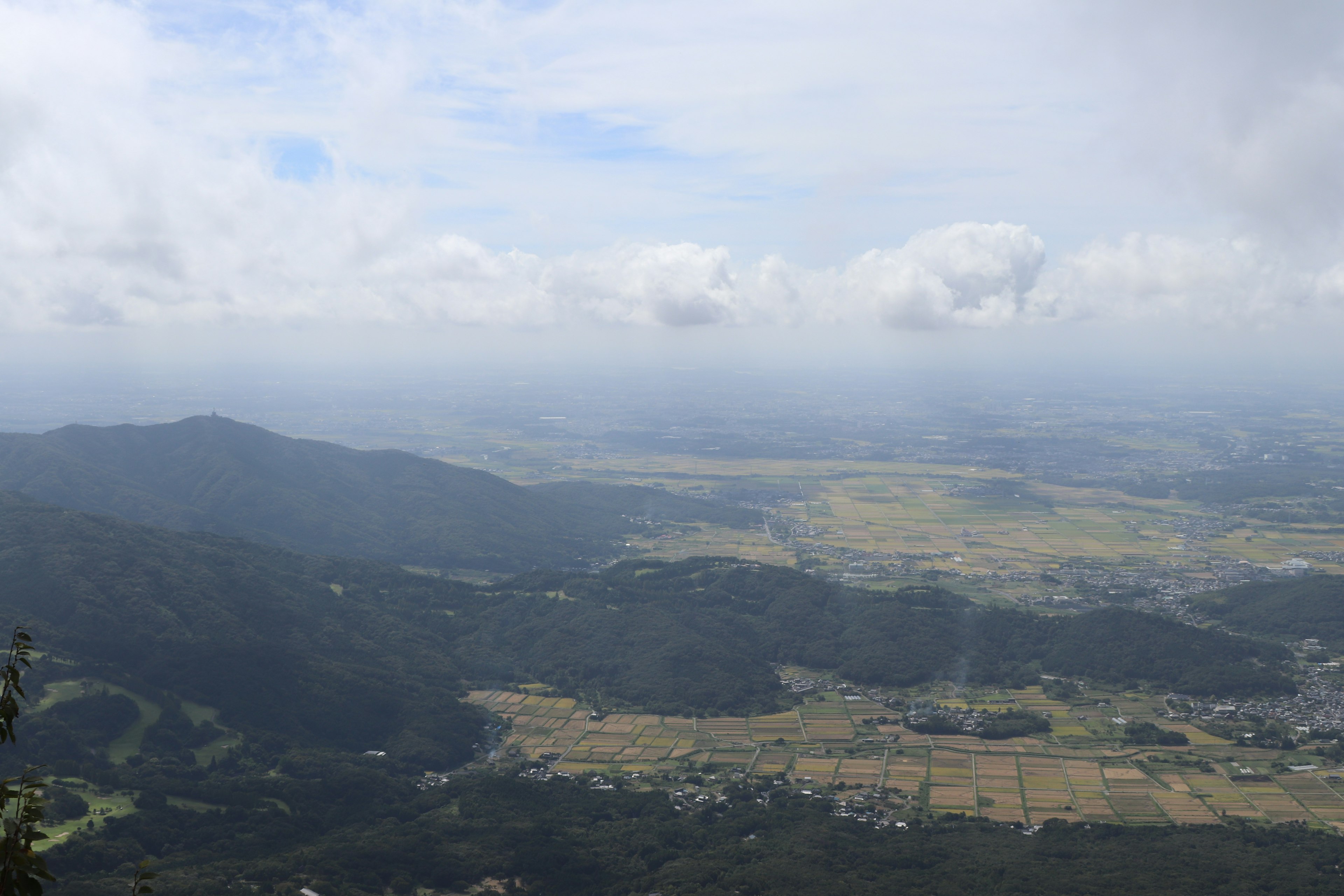 Vista panoramica dalla cima della montagna con colline verdi e cielo nuvoloso