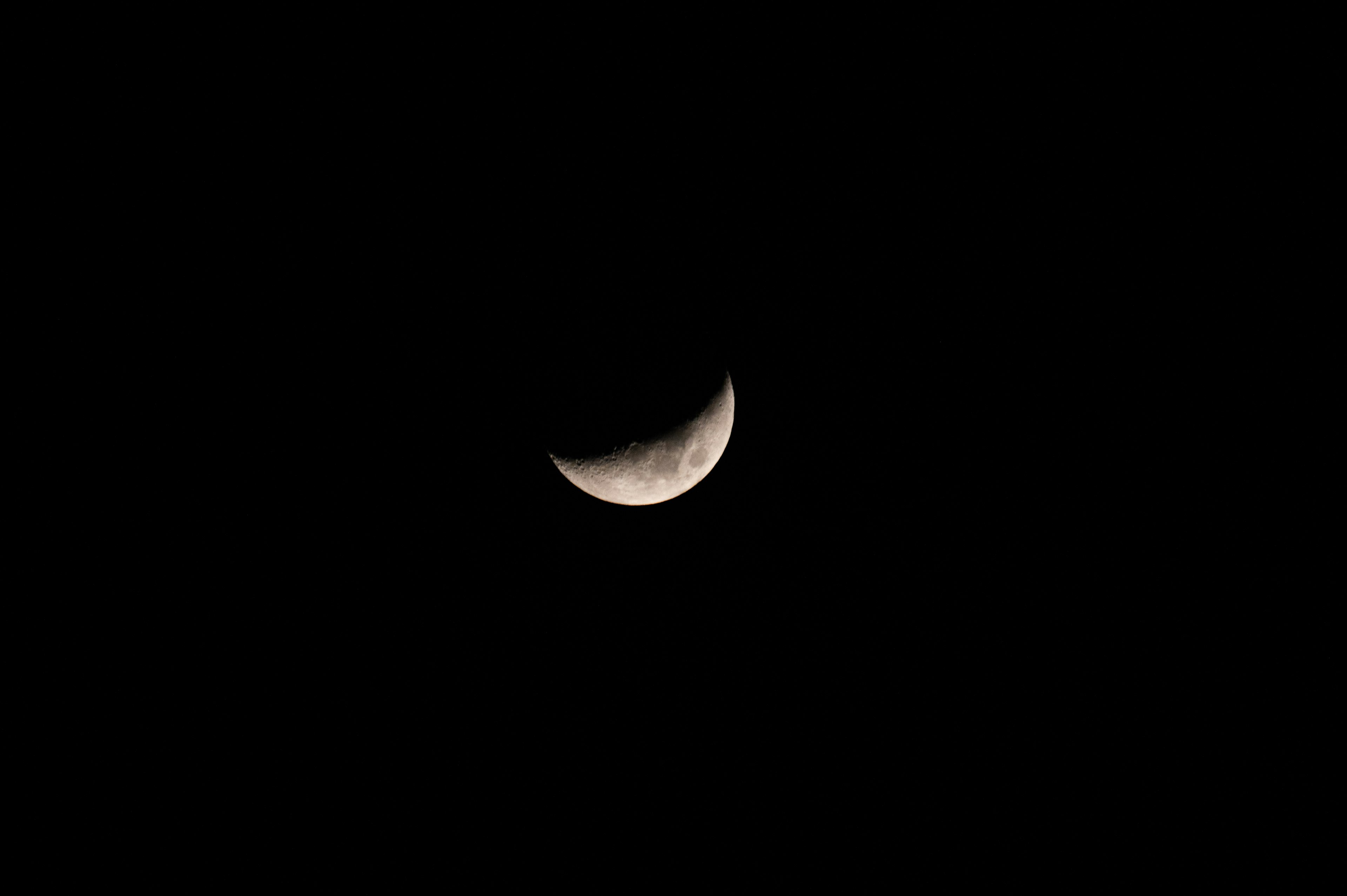 A crescent moon glowing in a dark sky