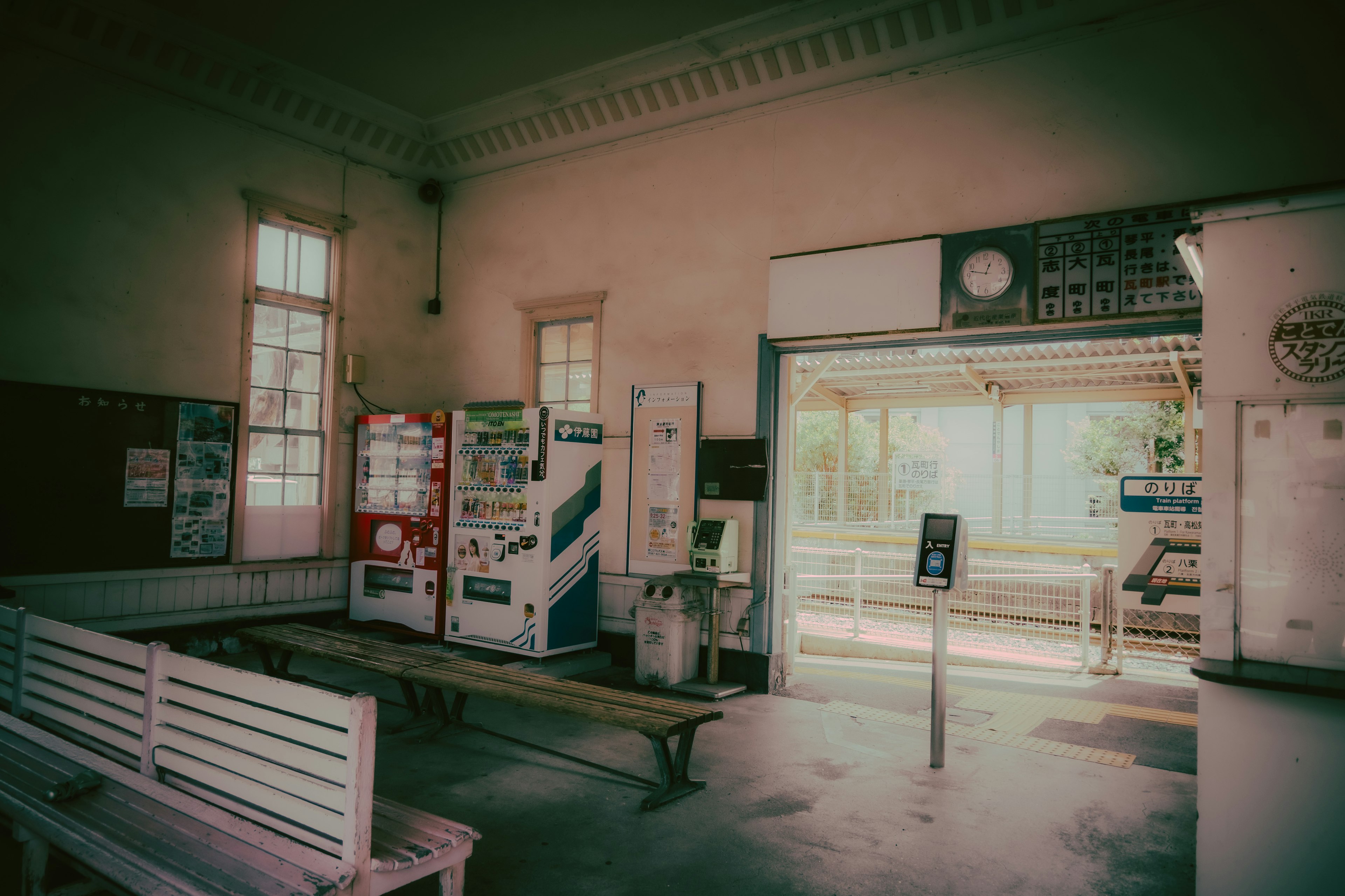 Interior de una vieja estación de tren con bancos y máquinas expendedoras