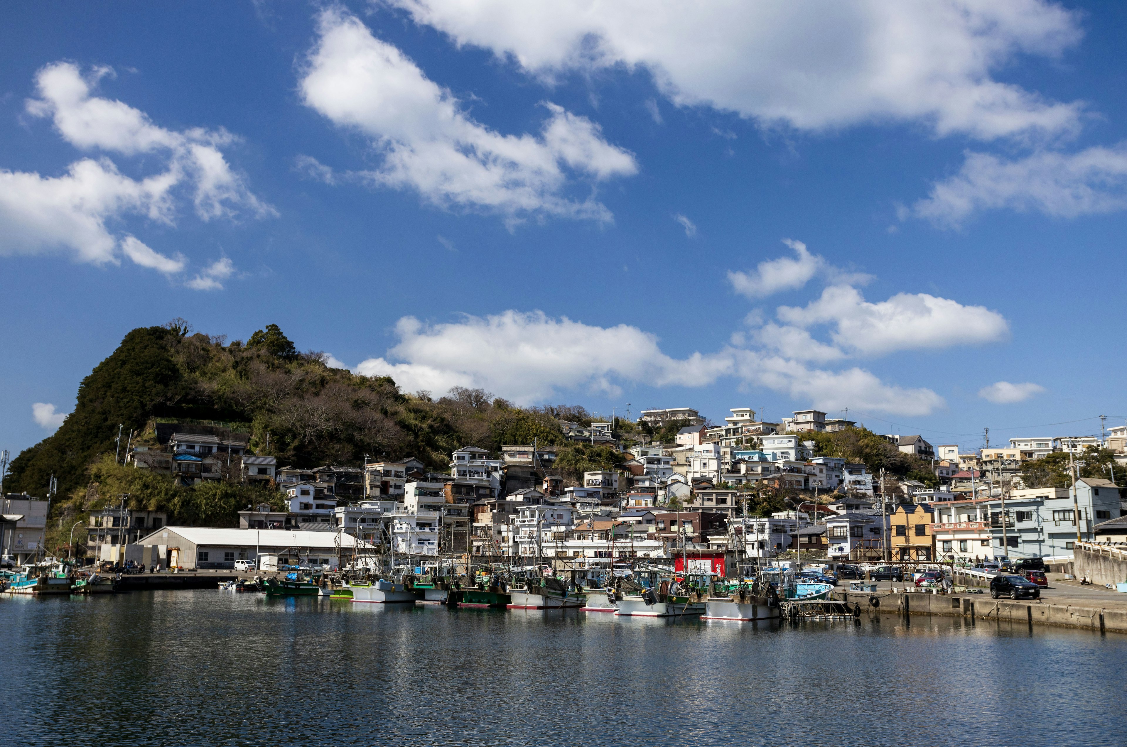 Coastal town landscape under blue sky colorful houses lined up with a mountain in the background