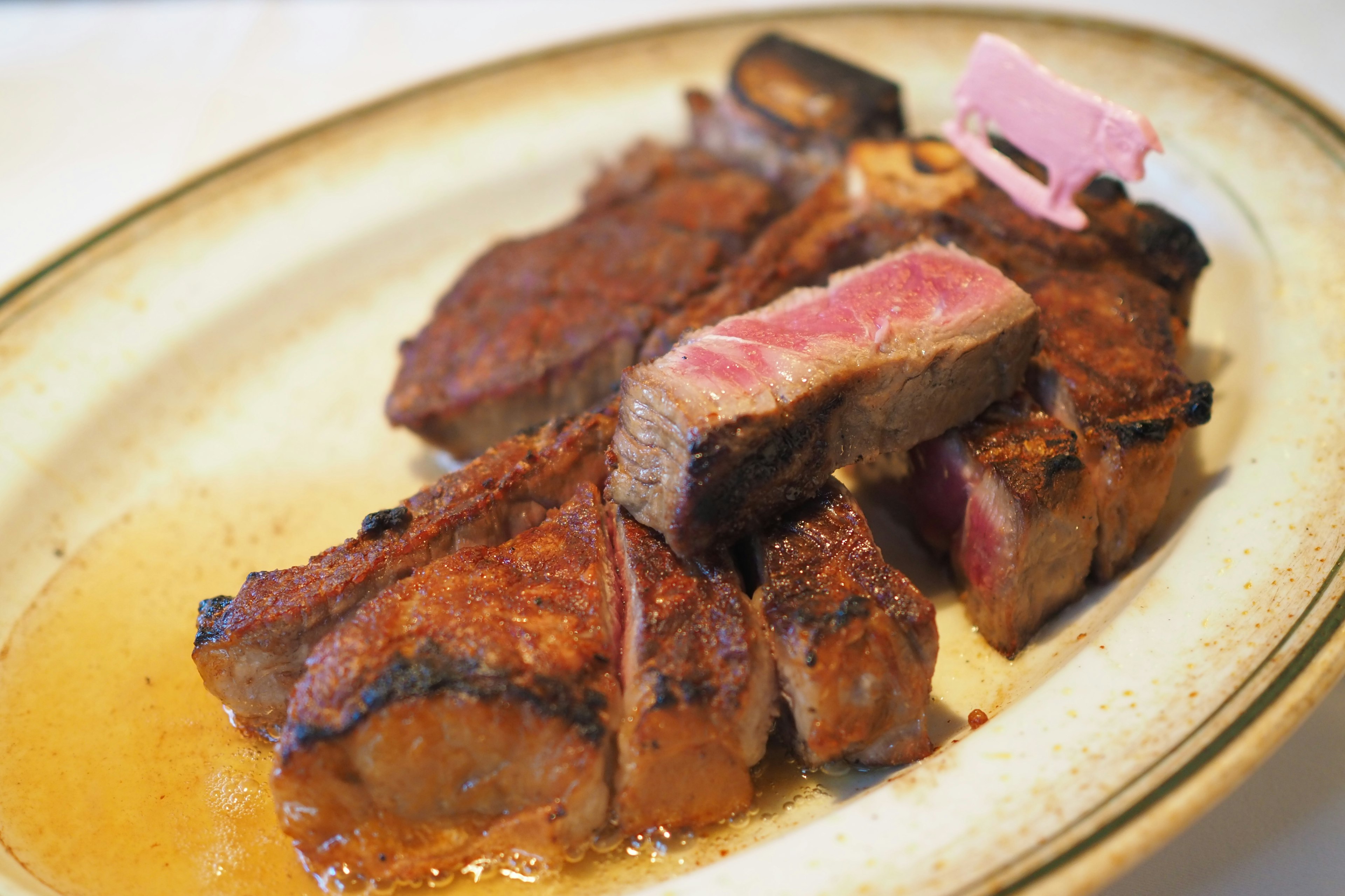 A platter of steak with varying degrees of doneness served on a plate