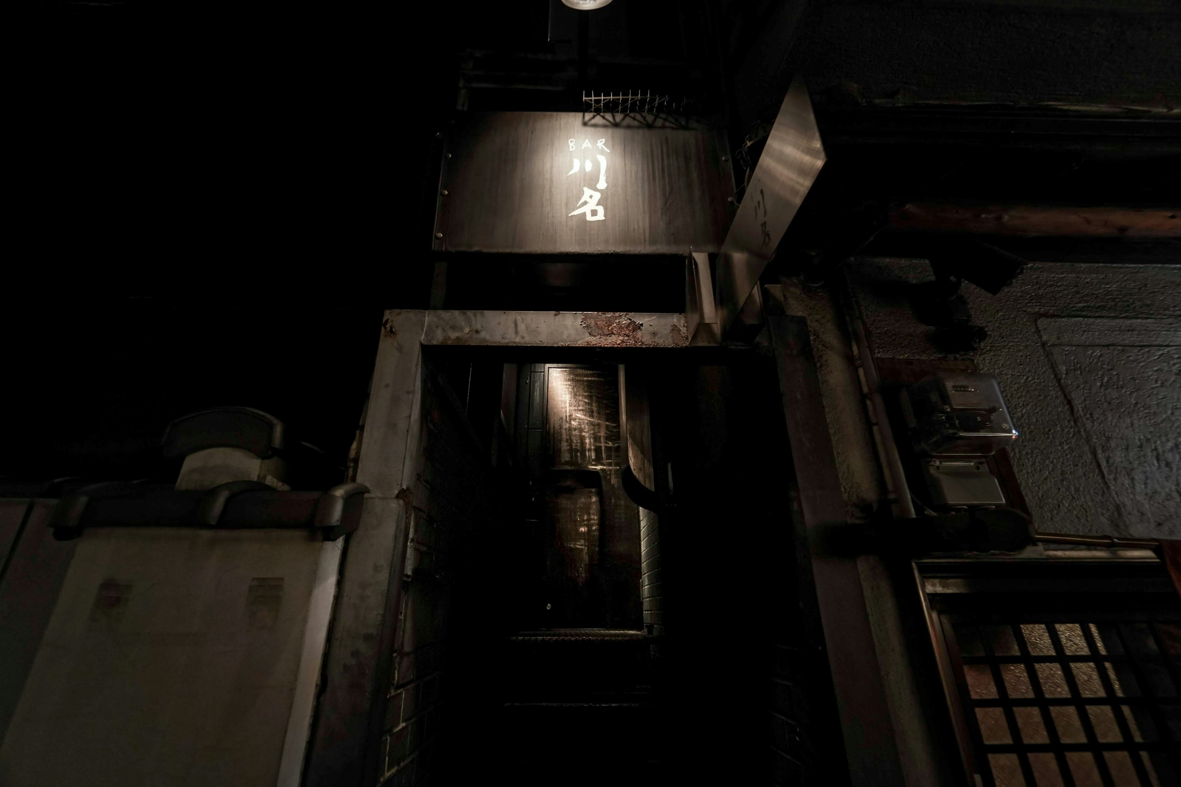 Entrada de un viejo edificio con un letrero en un callejón oscuro