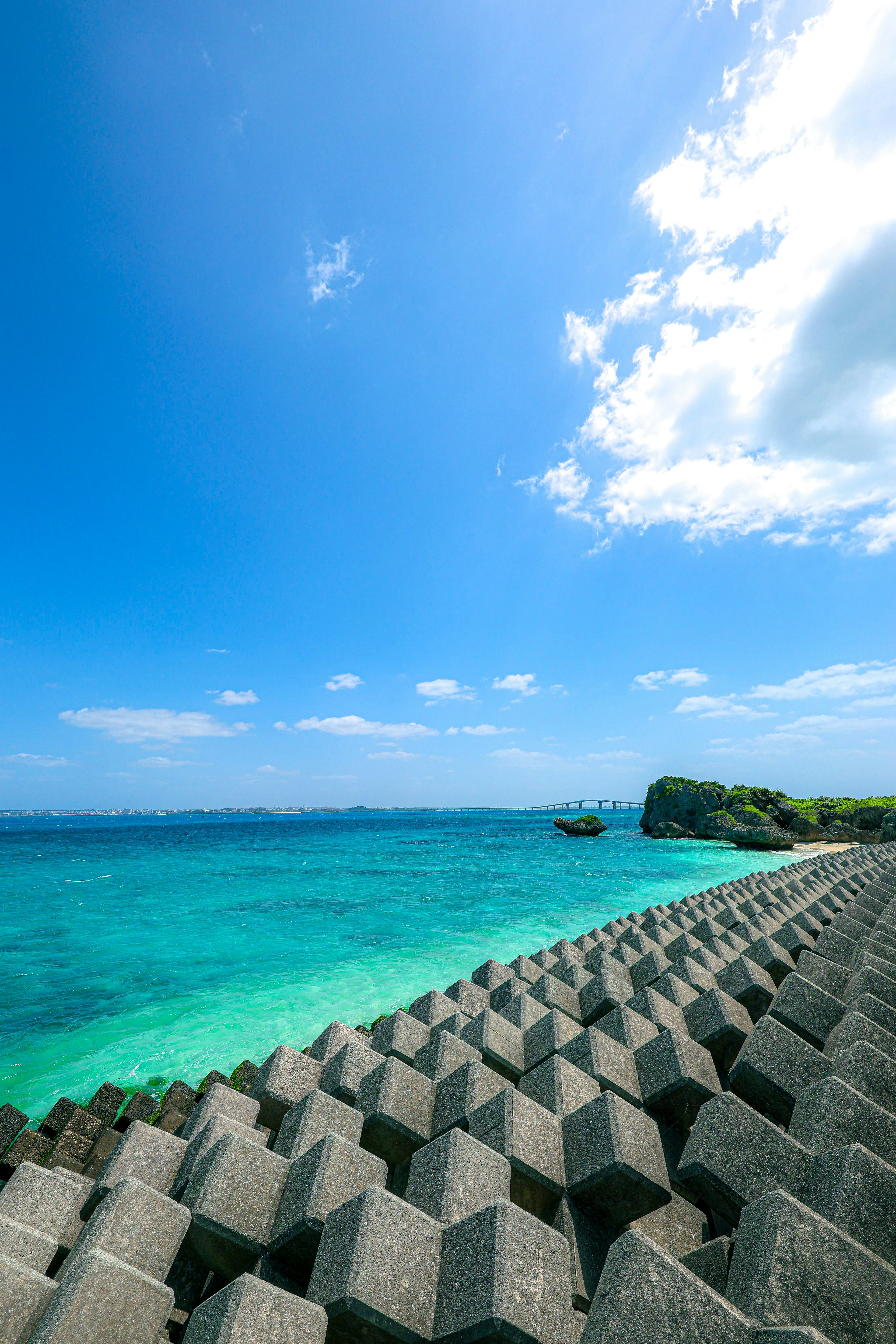 Scenic view of blue ocean and sky with concrete breakwater