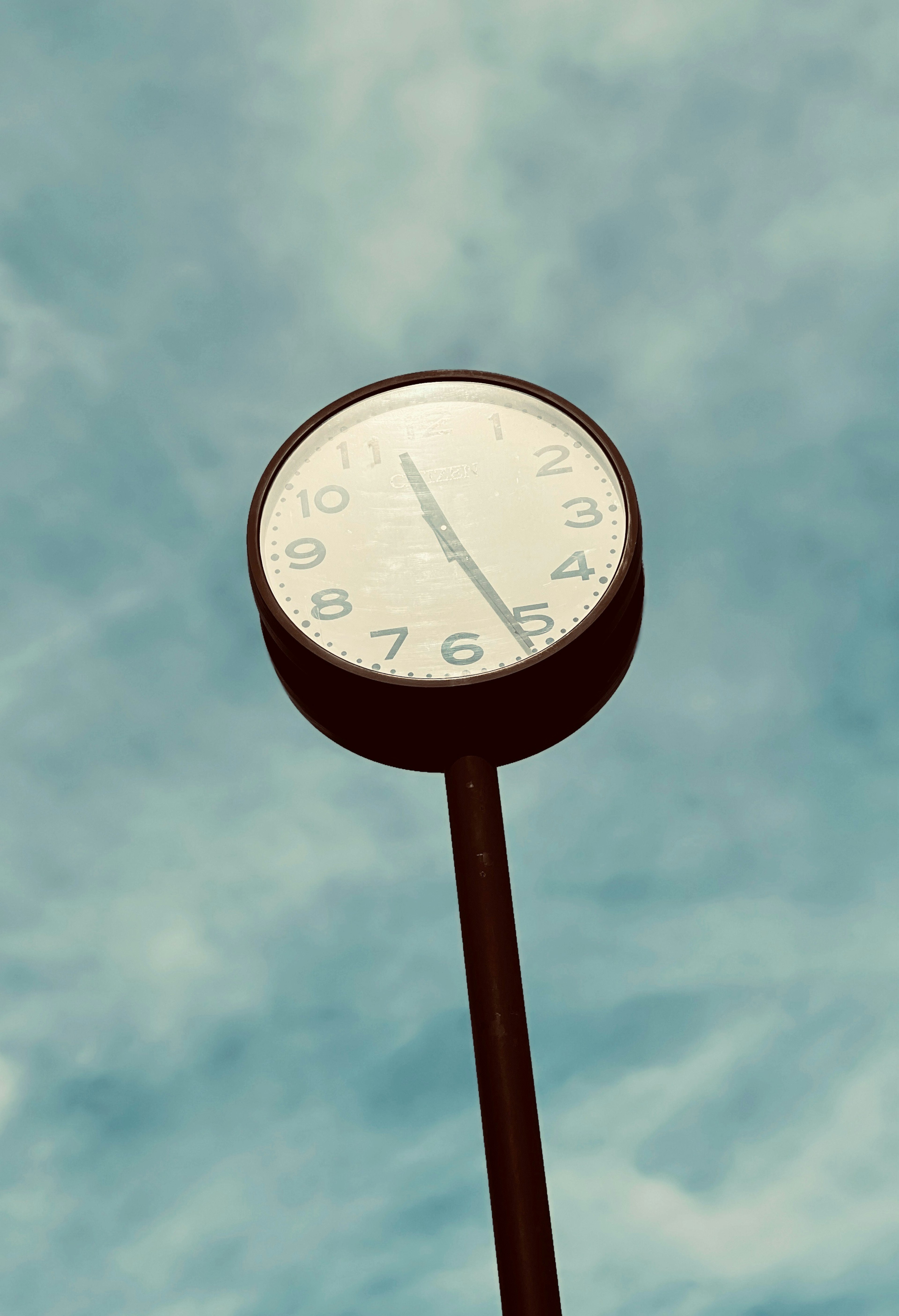 Round clock against a blue sky