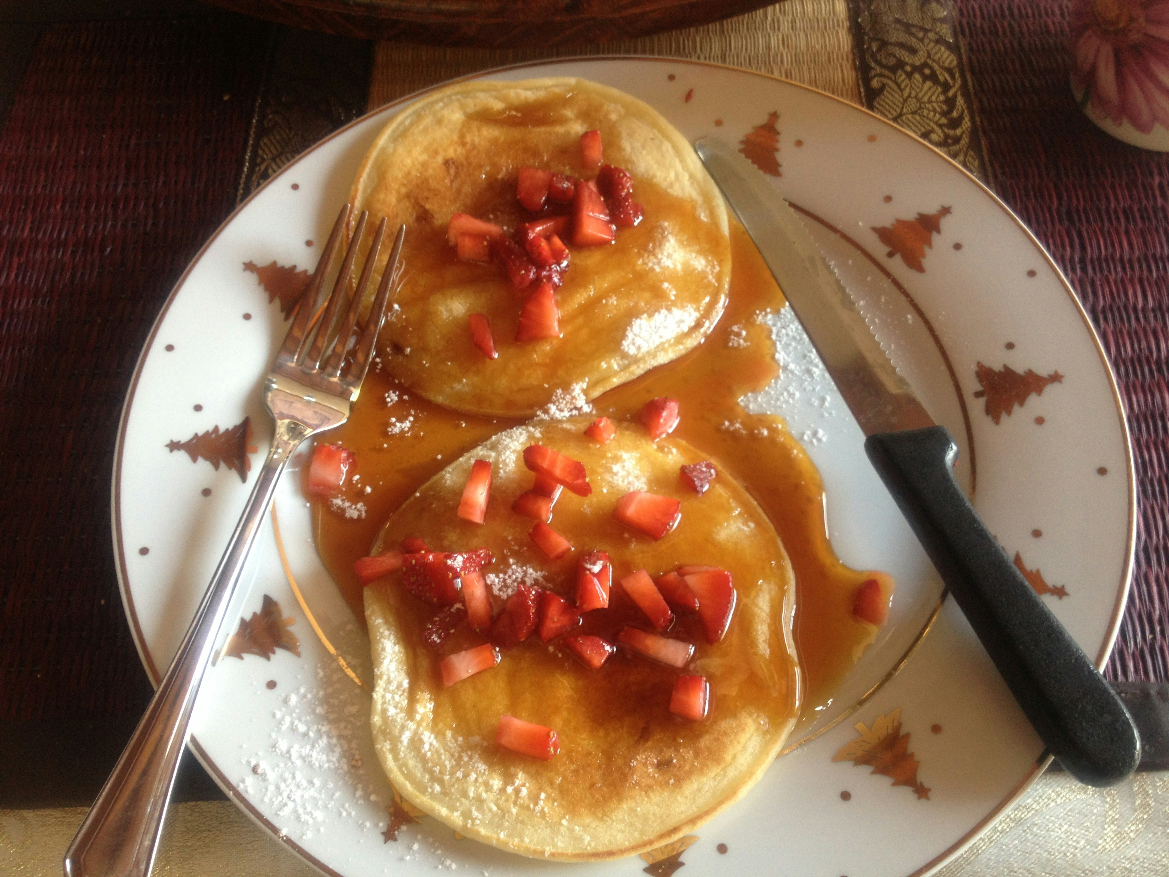 Piring pancake dengan topping stroberi dan sirup maple