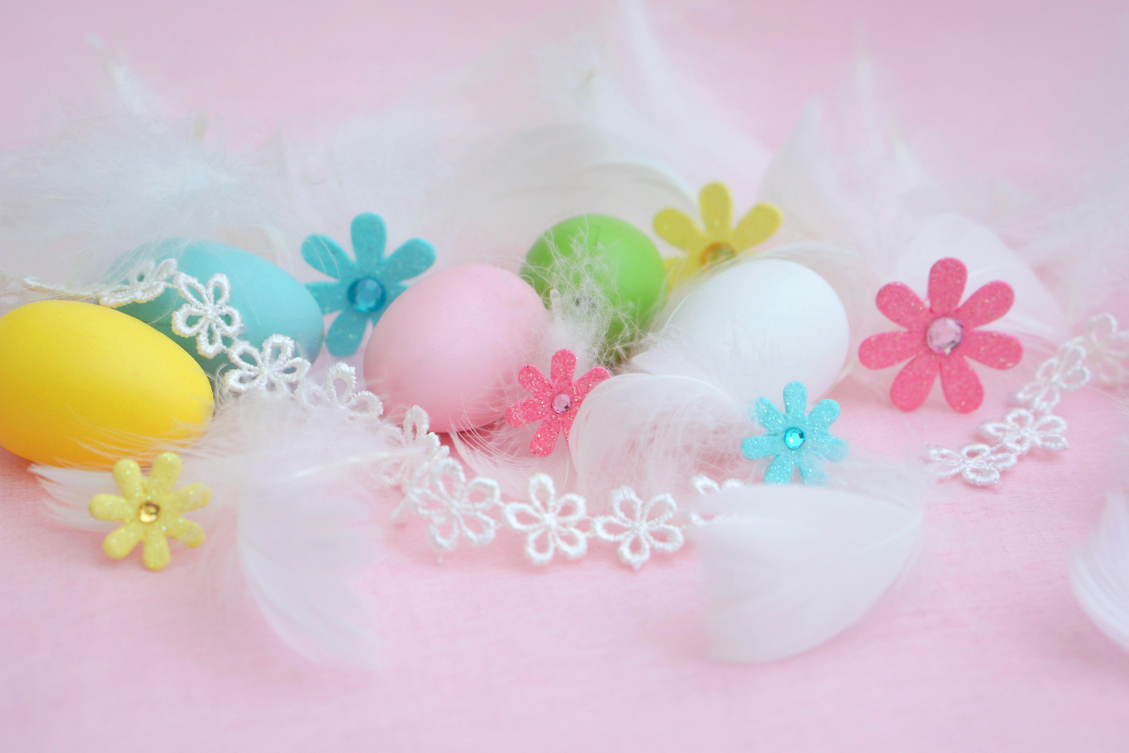 Colorful Easter eggs and floral decorations on a pink background