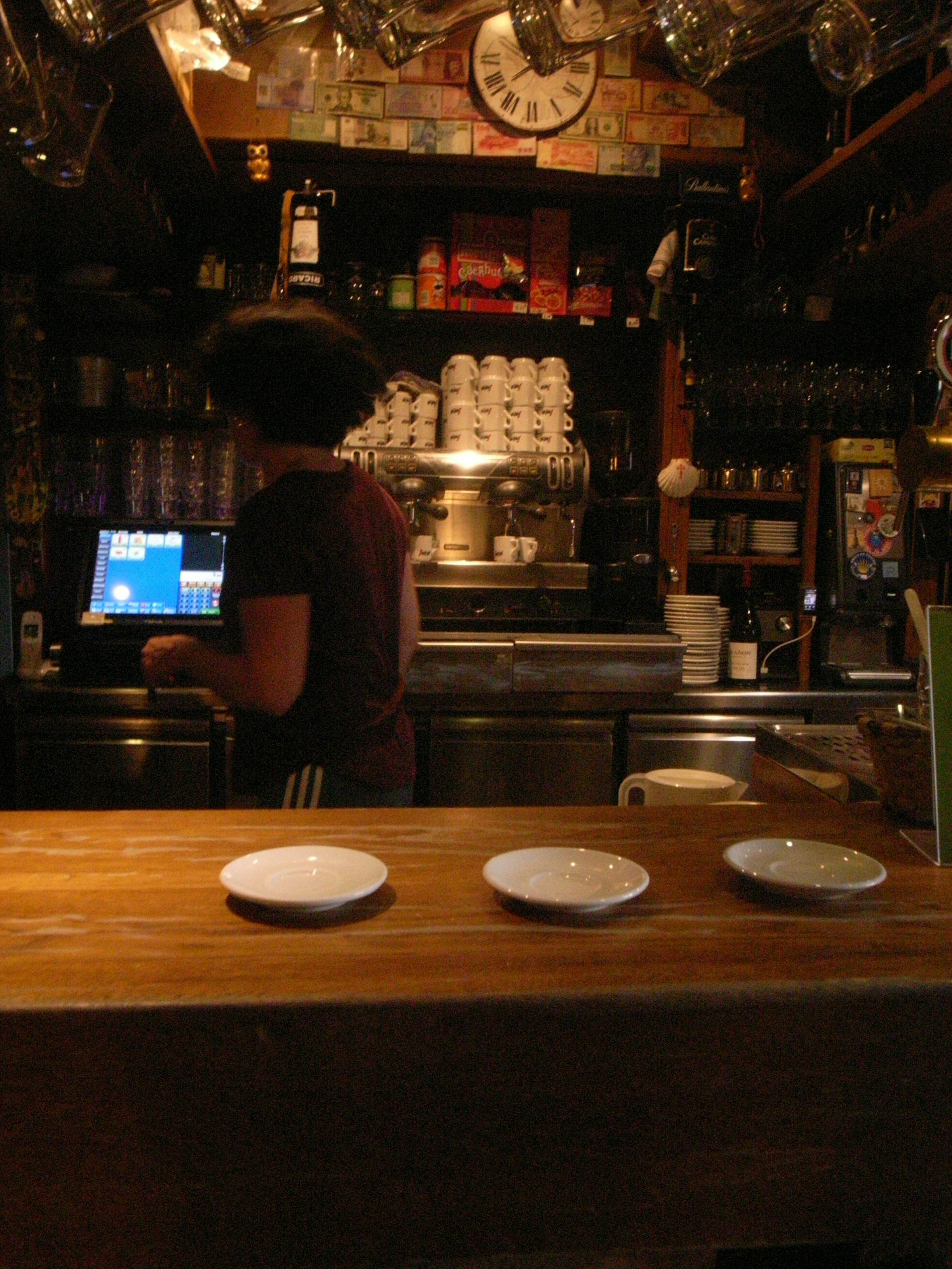 Innenansicht eines lebhaften Cafés mit einem Barista, der hinter der Theke Kaffee zubereitet