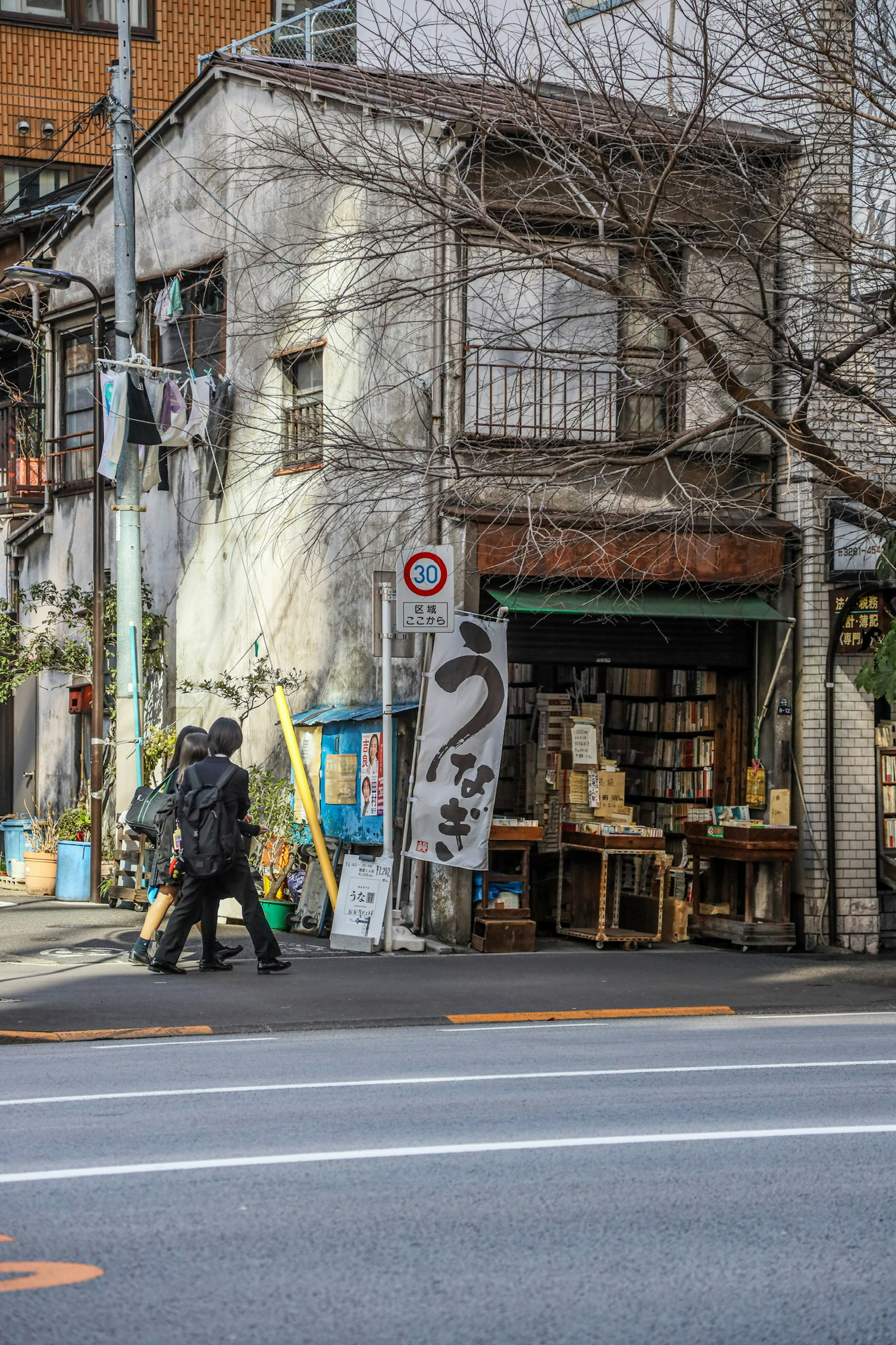 街角の古い書店の外観と通行人