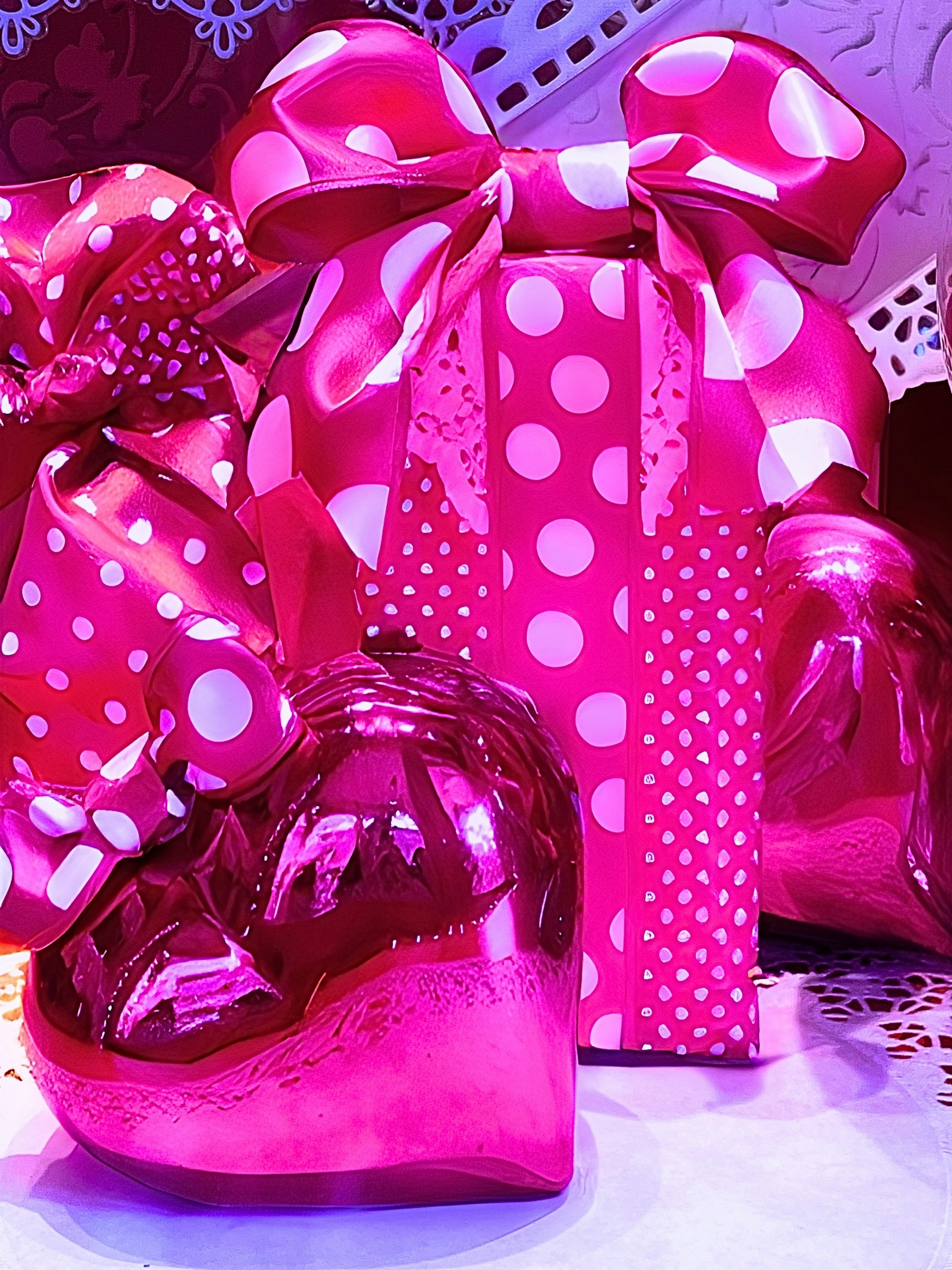 Pink gift boxes with polka dot patterns and bows alongside heart-shaped gifts