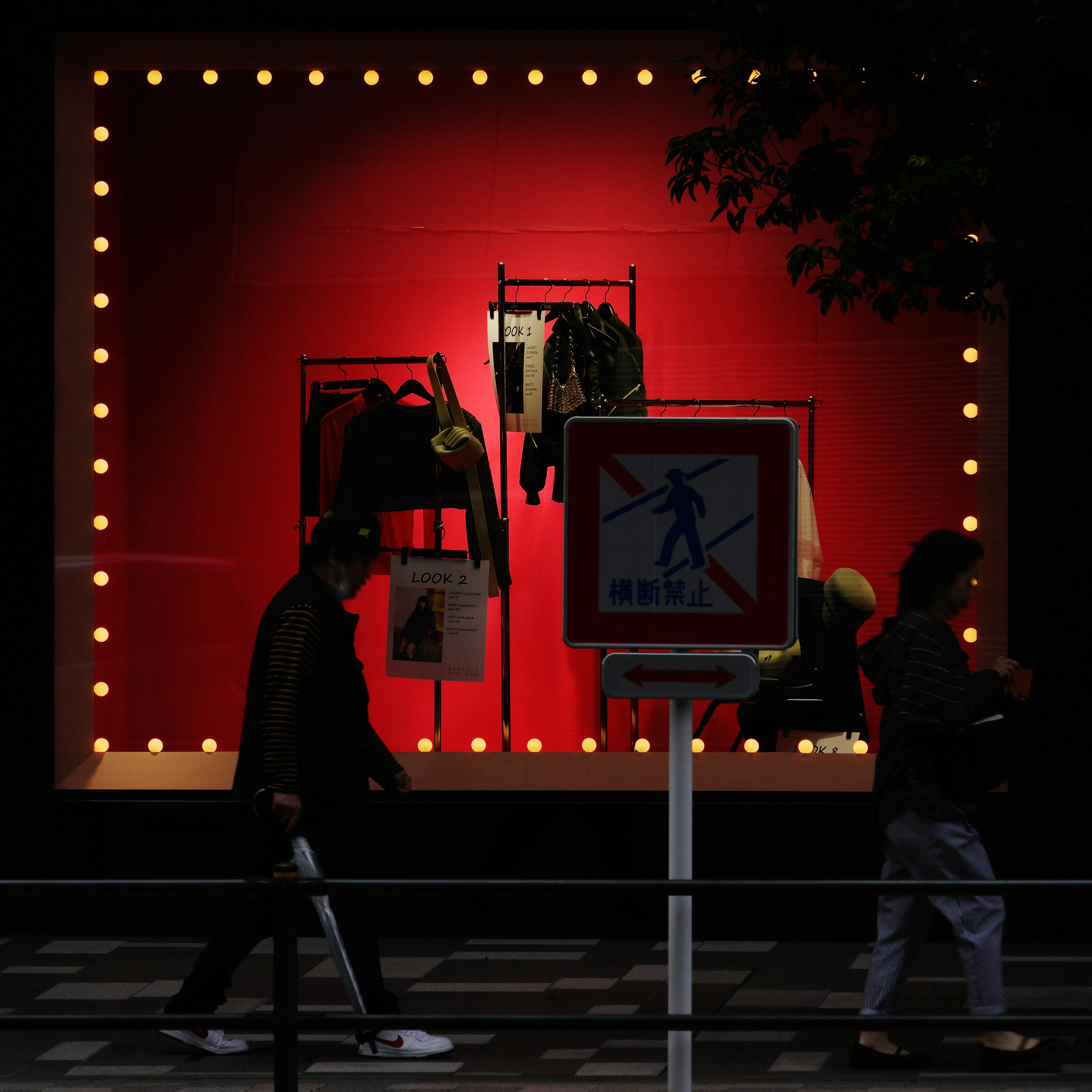 Vêtements exposés dans une vitrine avec un fond rouge et des lumières