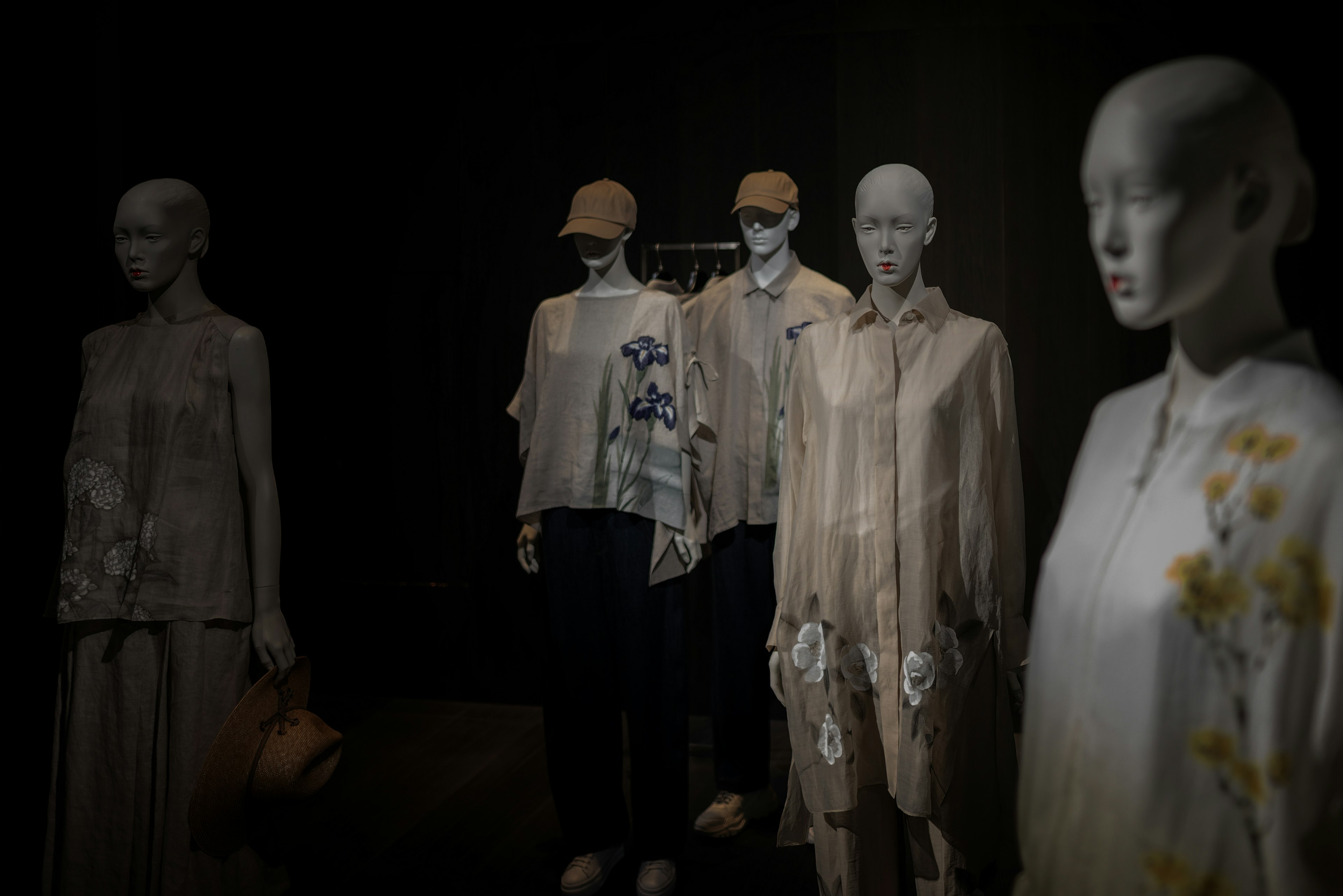 Fashion display featuring translucent mannequins in a dark setting