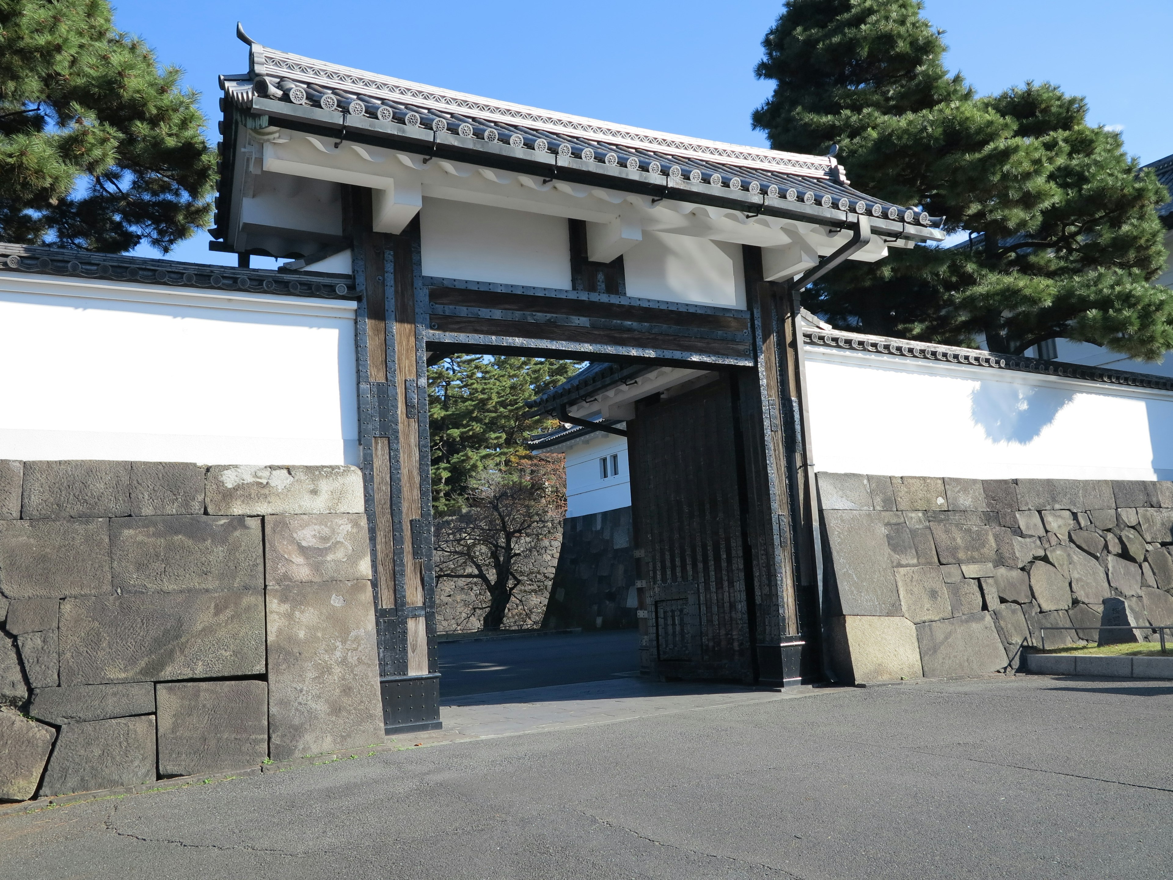 Traditional Japanese gate structure with stone walls