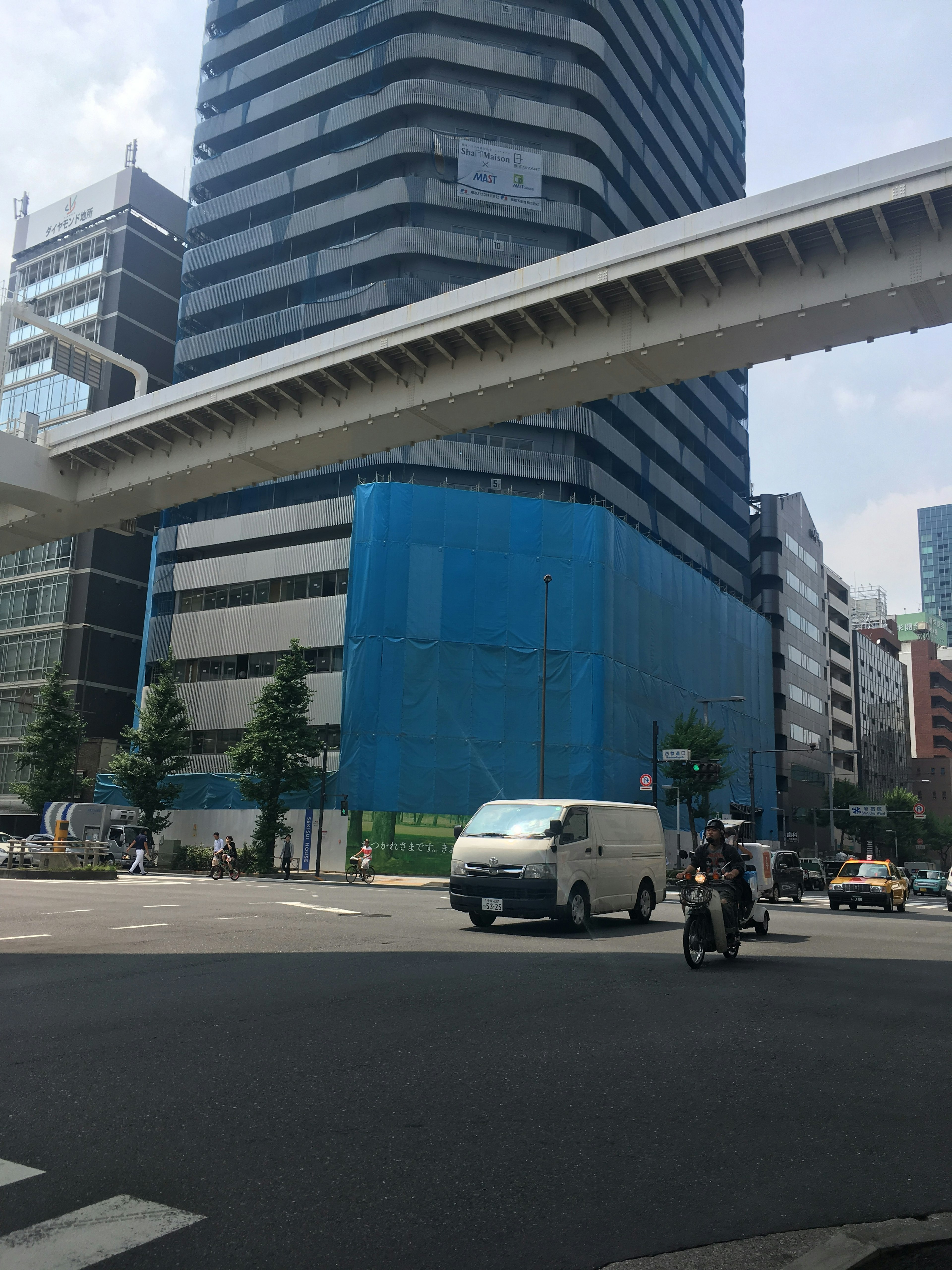 Urban scene featuring a blue-walled building and an overpass