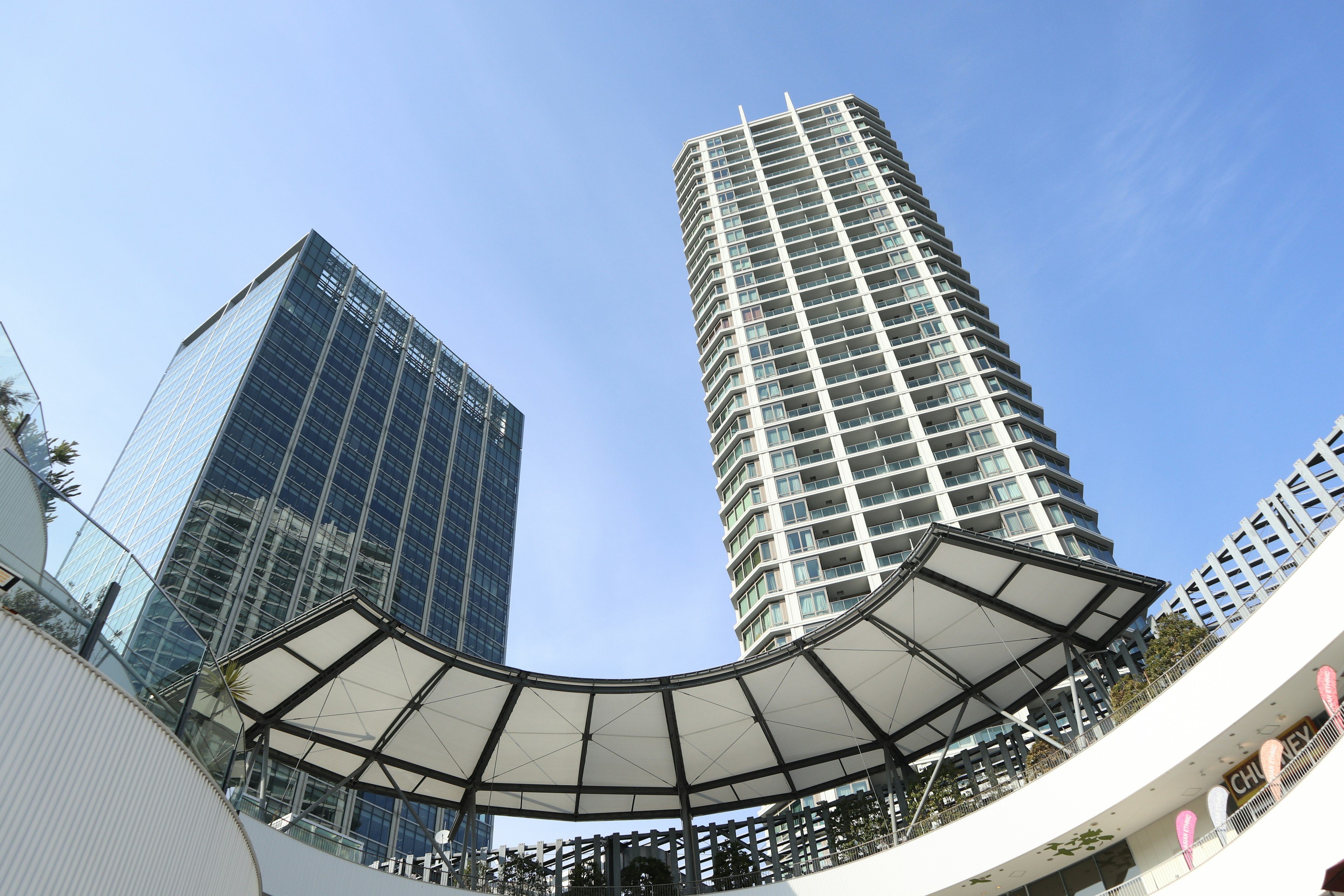 Vista de edificios altos y una plaza cubierta bajo un cielo azul claro