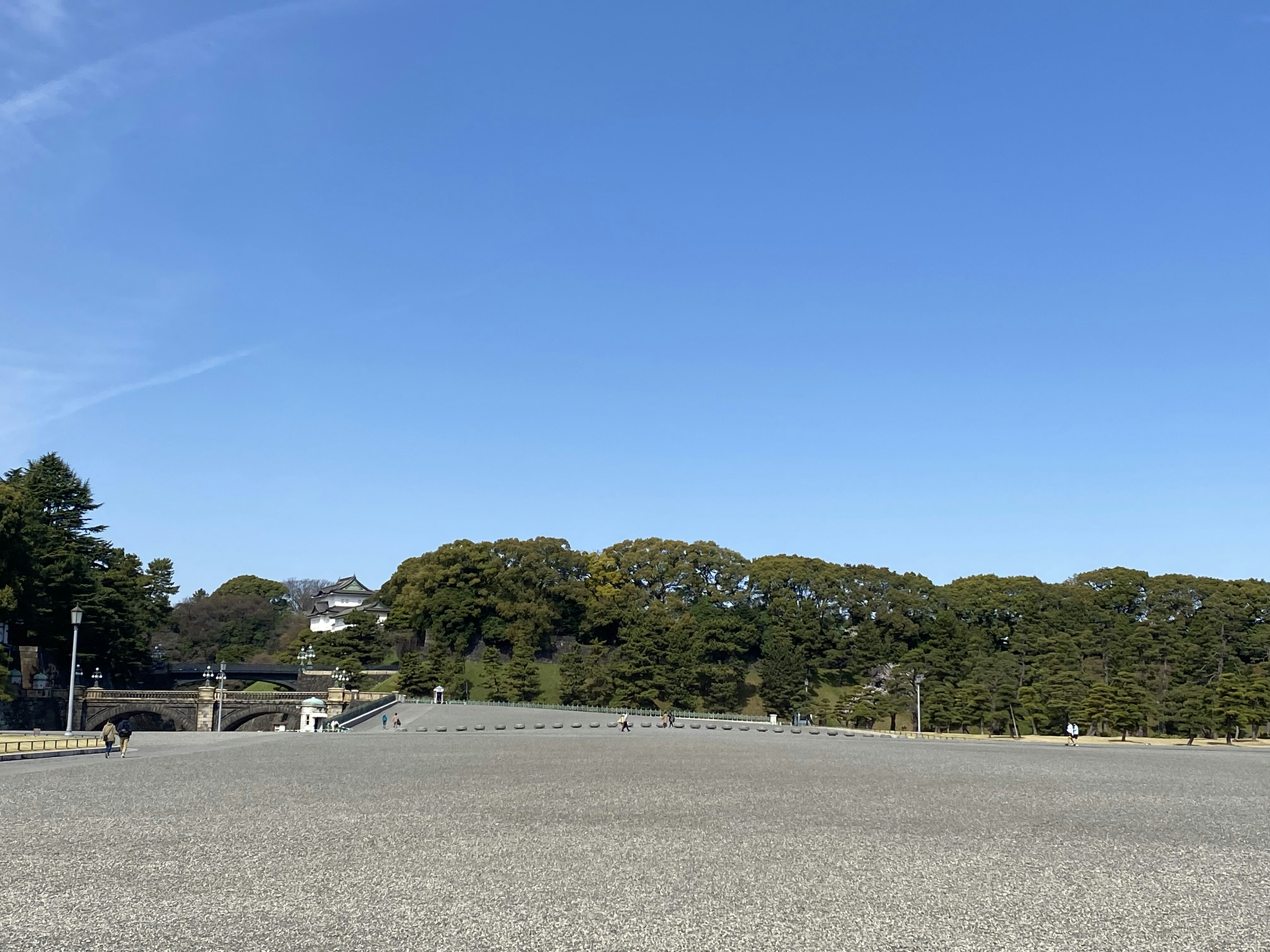 Landscape featuring a wide gravel area under a clear blue sky