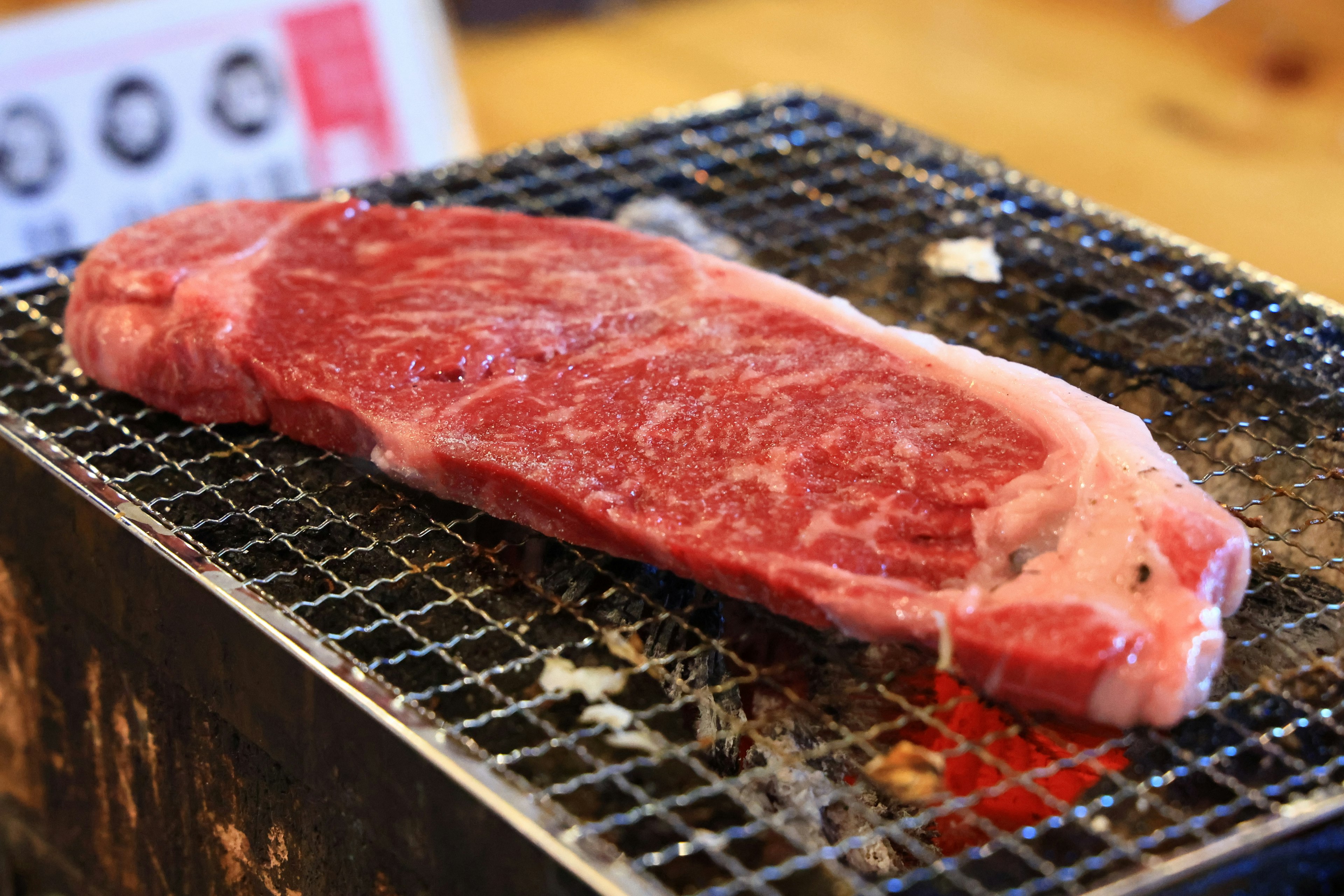 Ein Stück marmoriertes Rindfleisch auf einem Holzkohlegrill