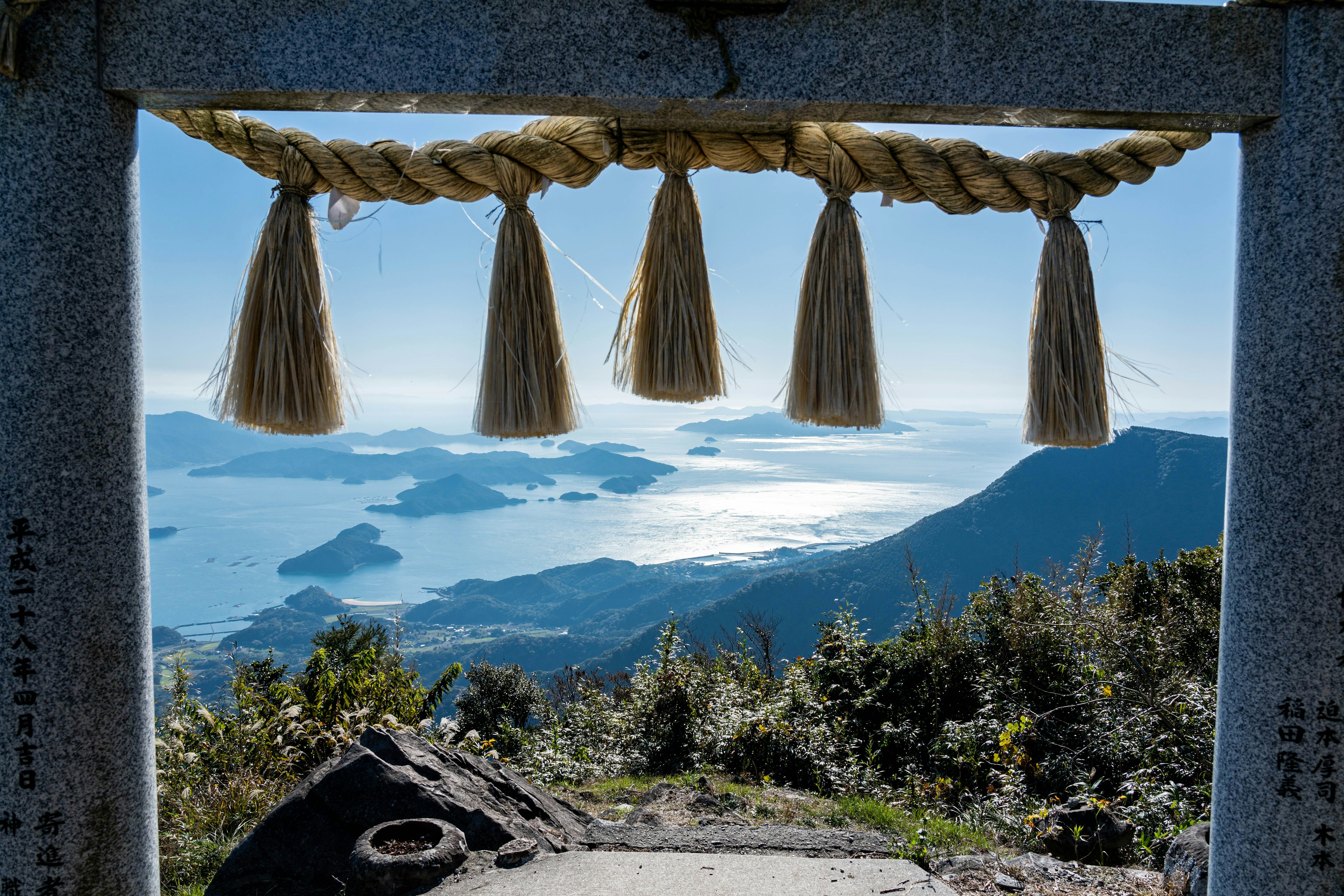 Torii gate frame with a mountain view and ocean