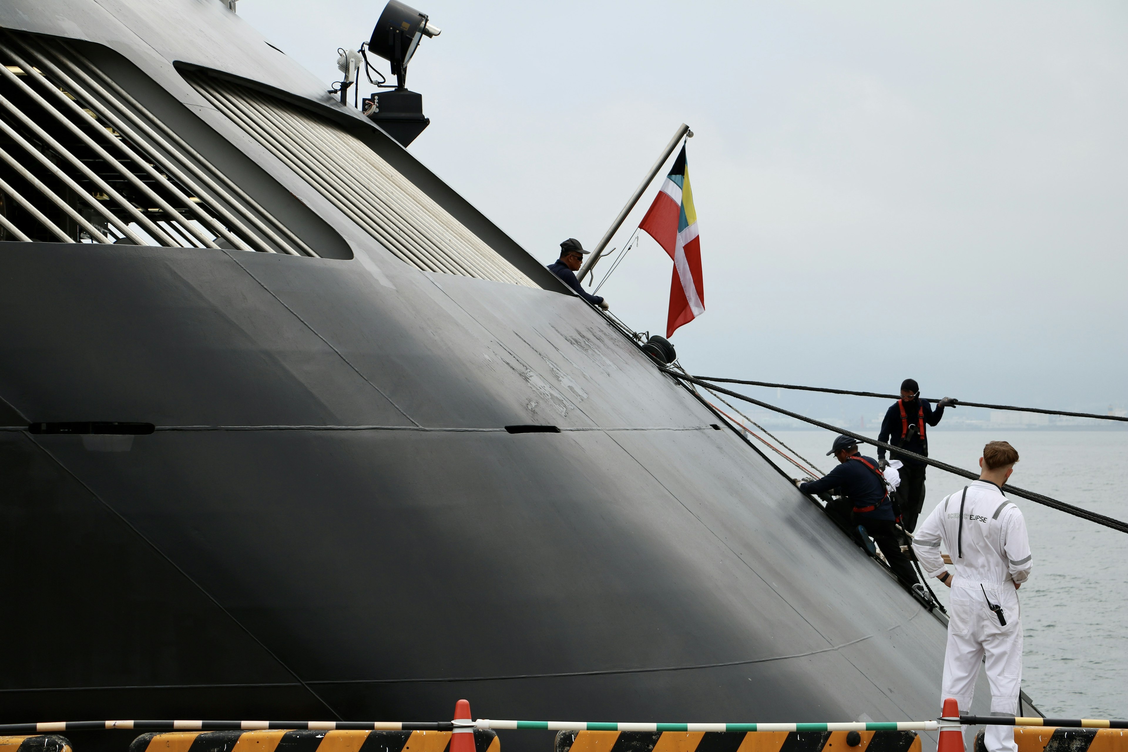 Crew members on the side of a submarine with flags