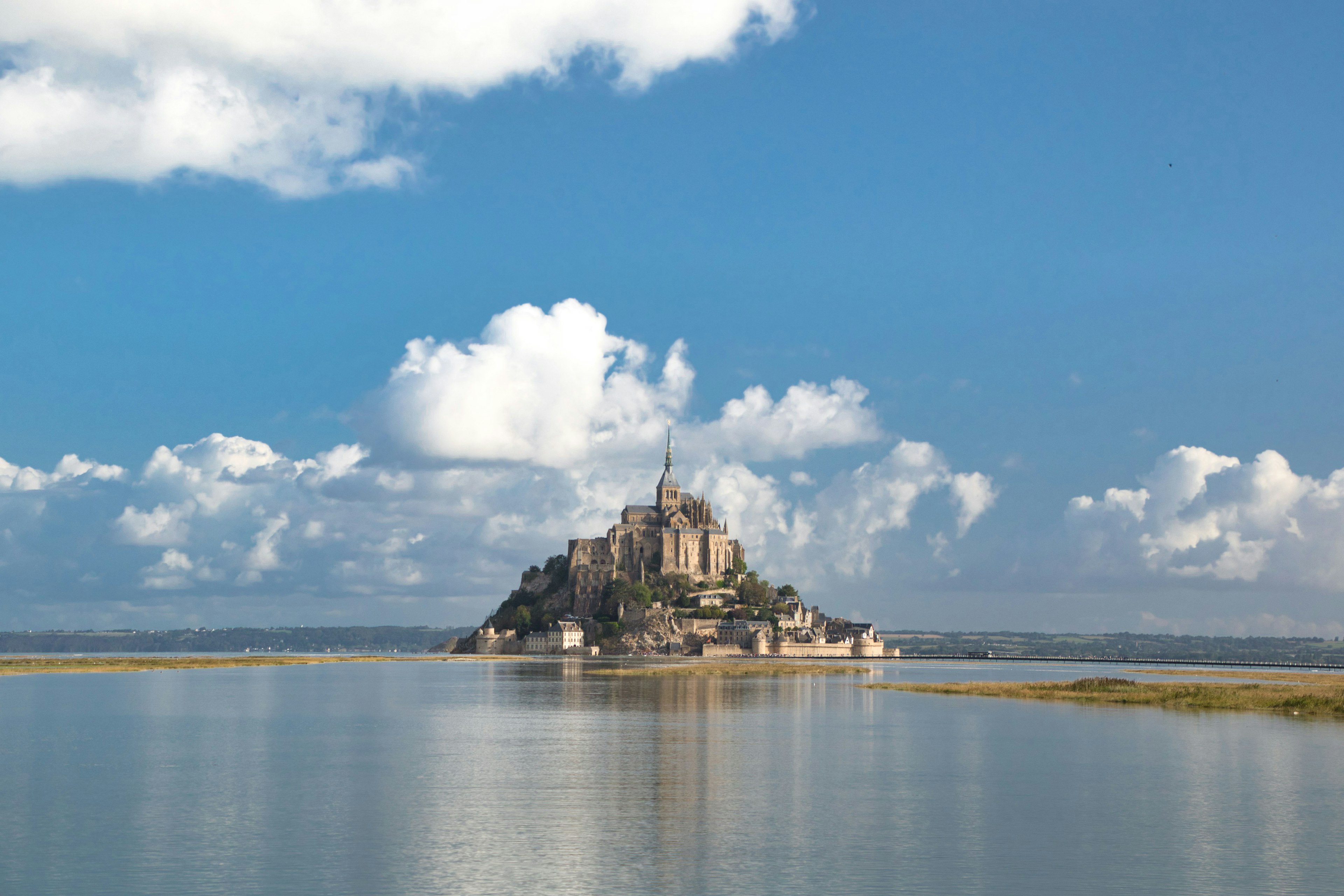 Vista panoramica del Monte Saint-Michel con cielo blu e nuvole sopra l'isola