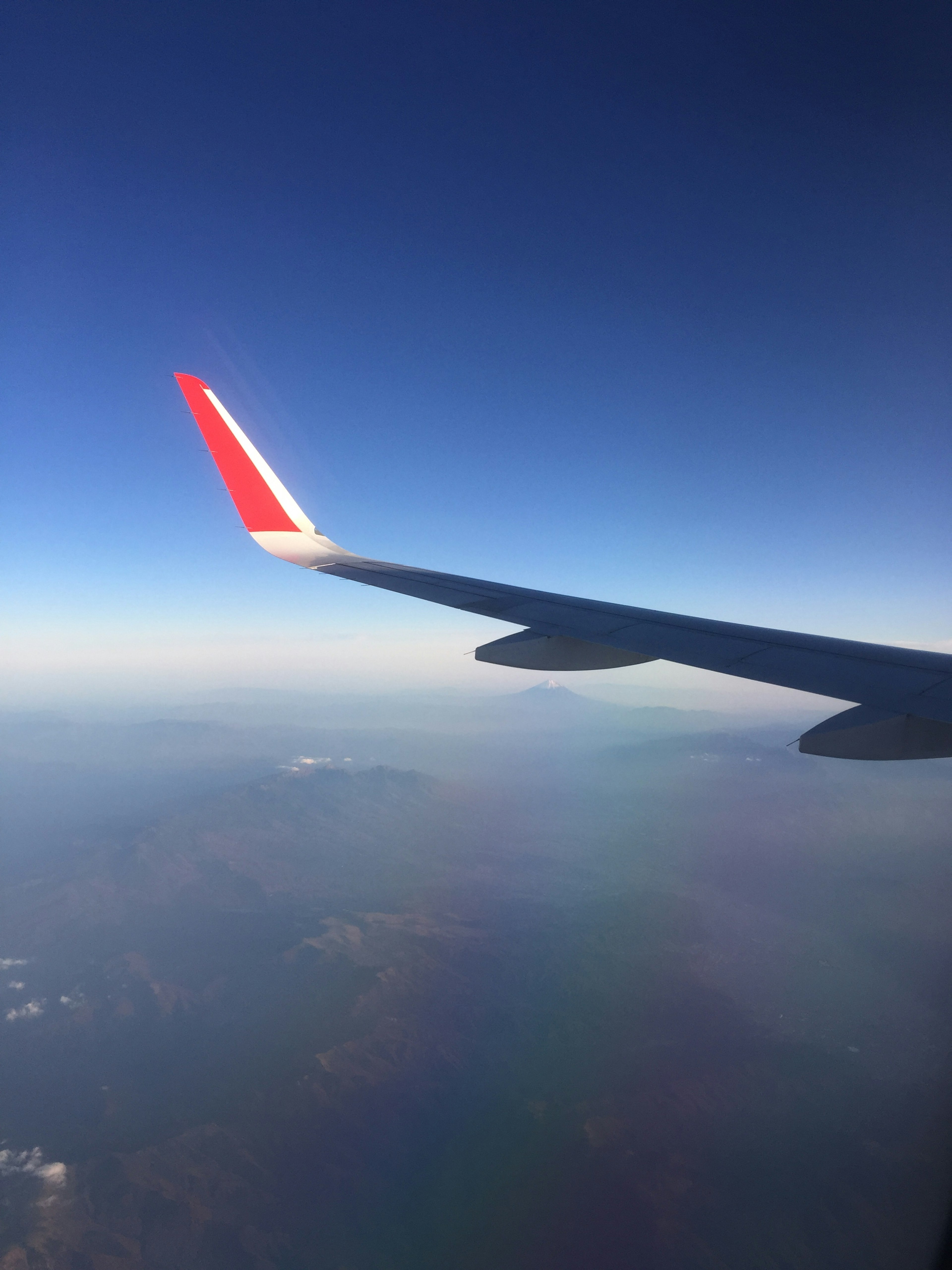 Airplane wing against a clear blue sky