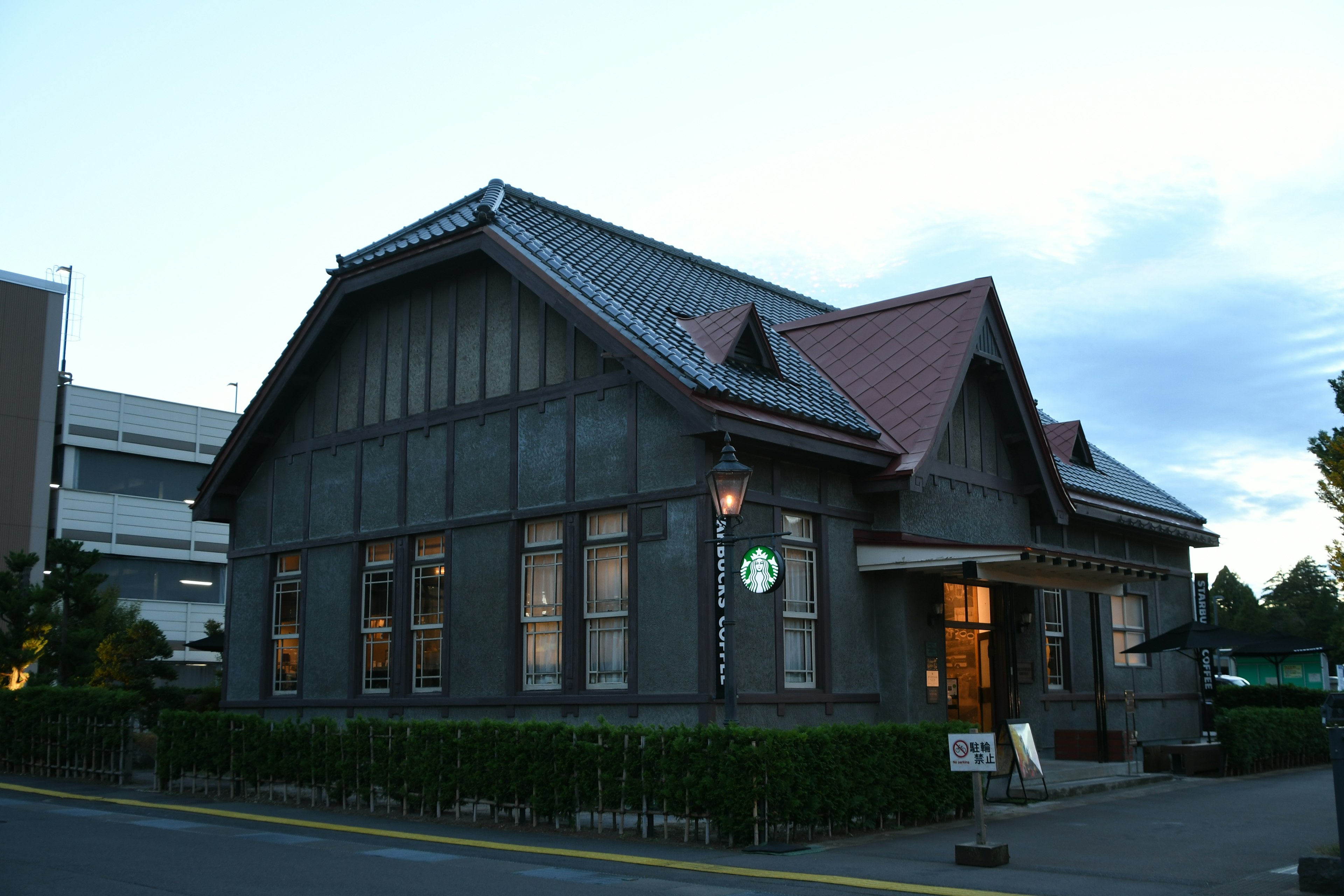 Altes Haus mit rotem Dach und Holzfassade in der Dämmerung