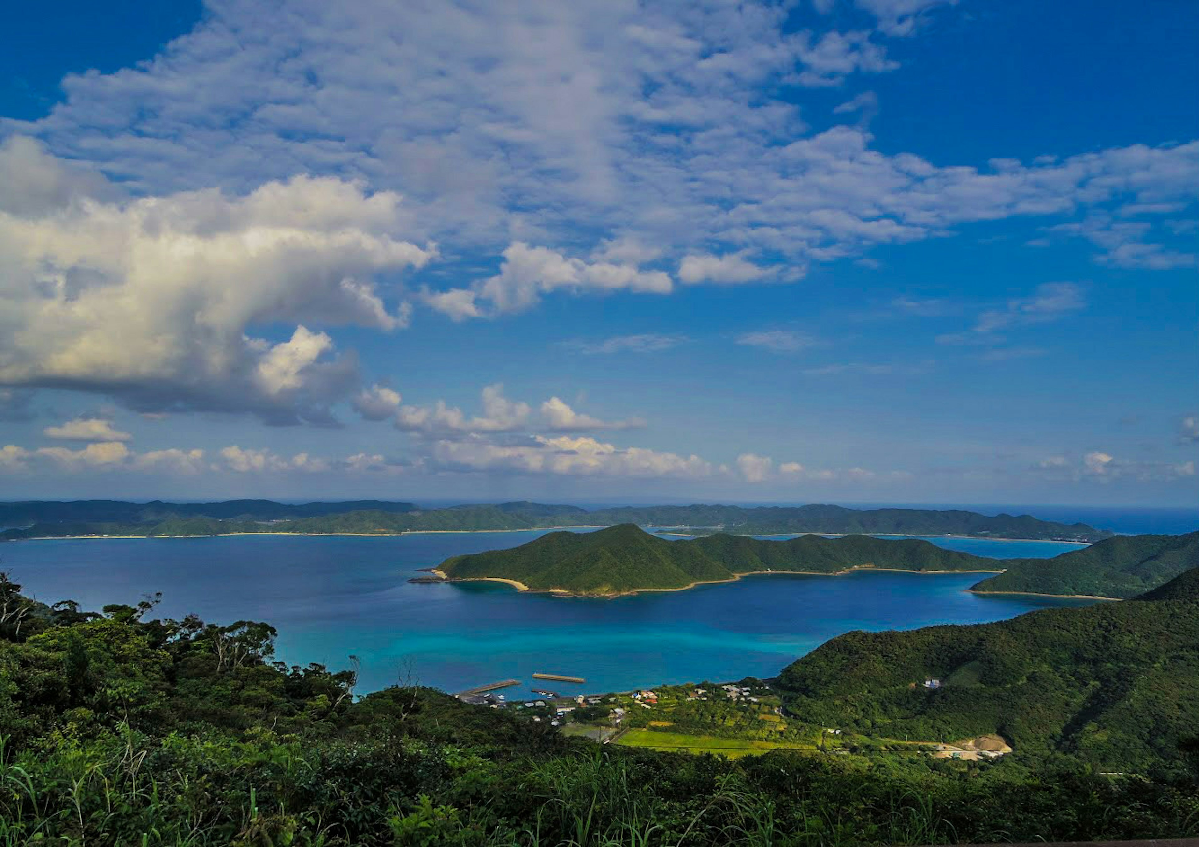 Vista escénica del océano azul y colinas verdes bajo un cielo brillante