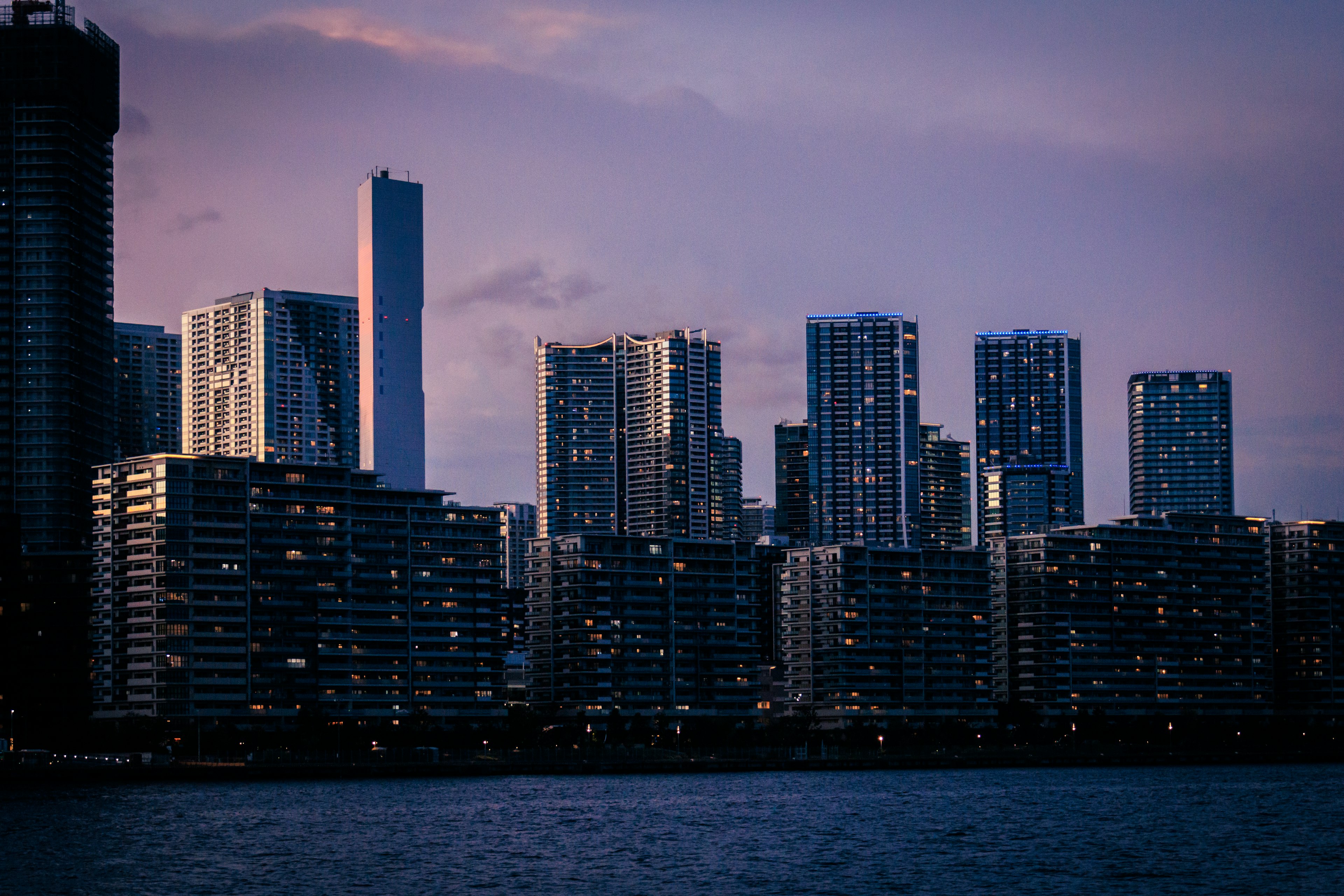 City skyline at dusk with illuminated windows of skyscrapers