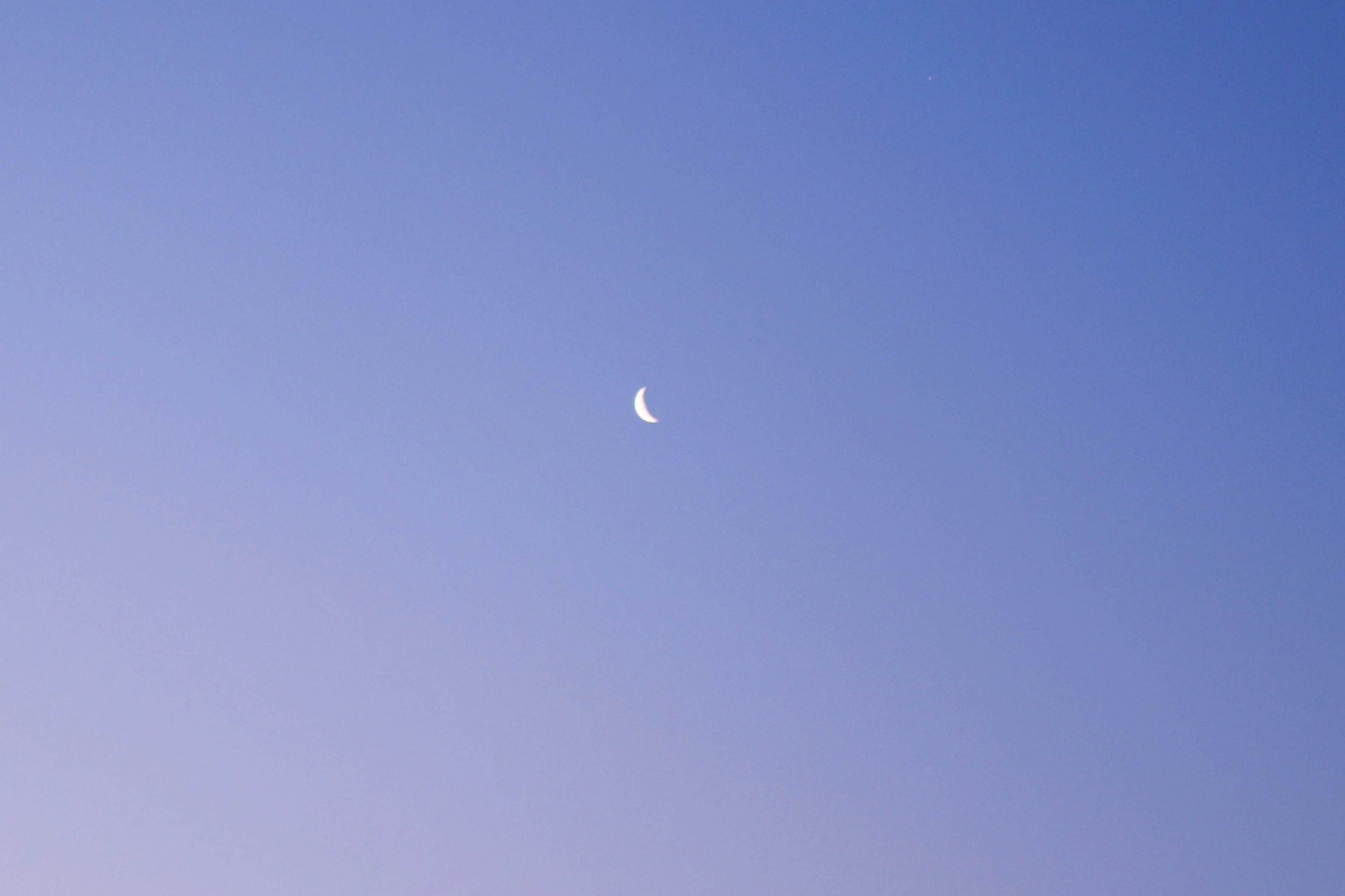 Bulan sabit tipis di langit biru