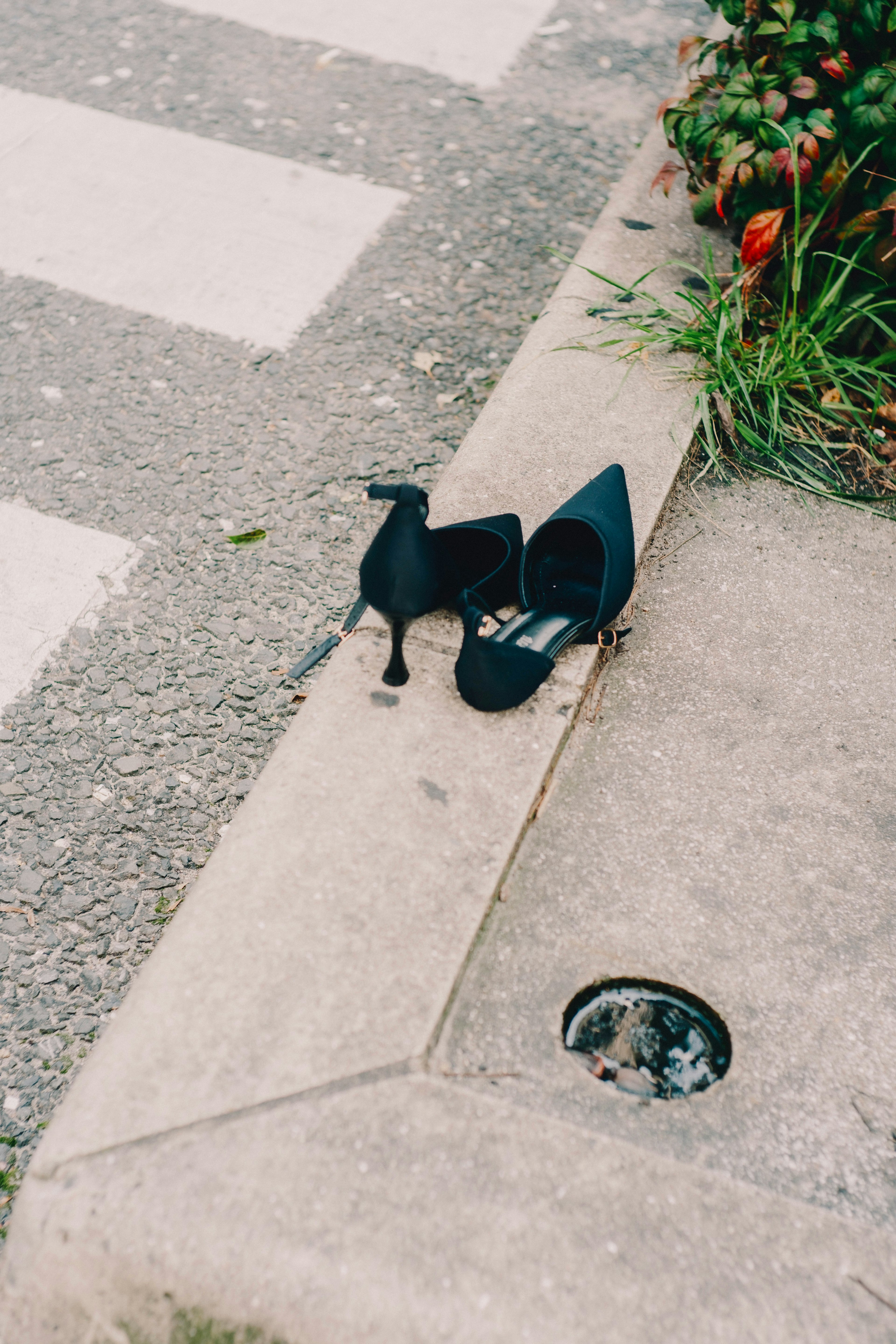 Escarpins noirs posés au bord d'un trottoir