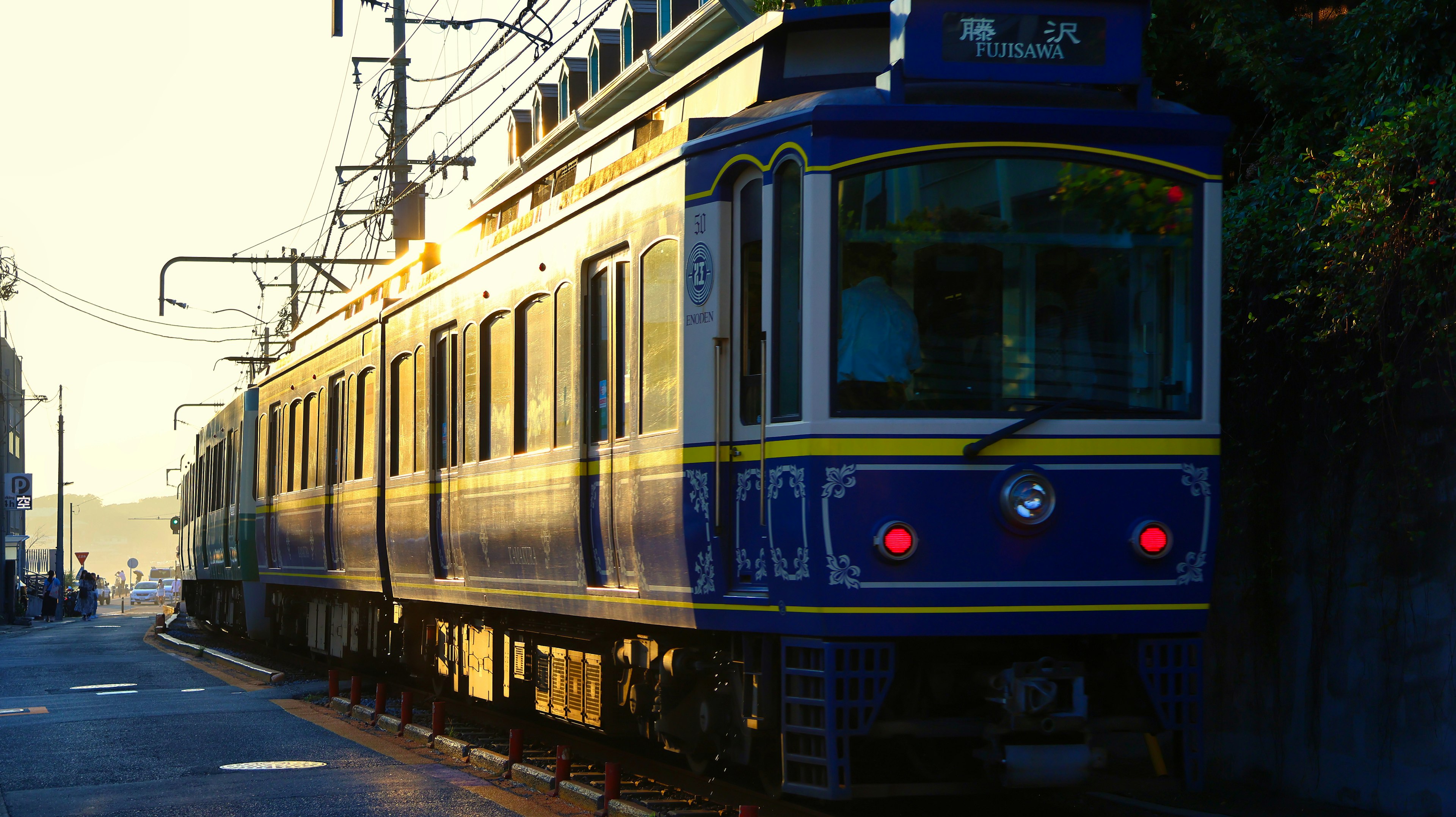 Tren azul estacionado en la estación con el atardecer de fondo