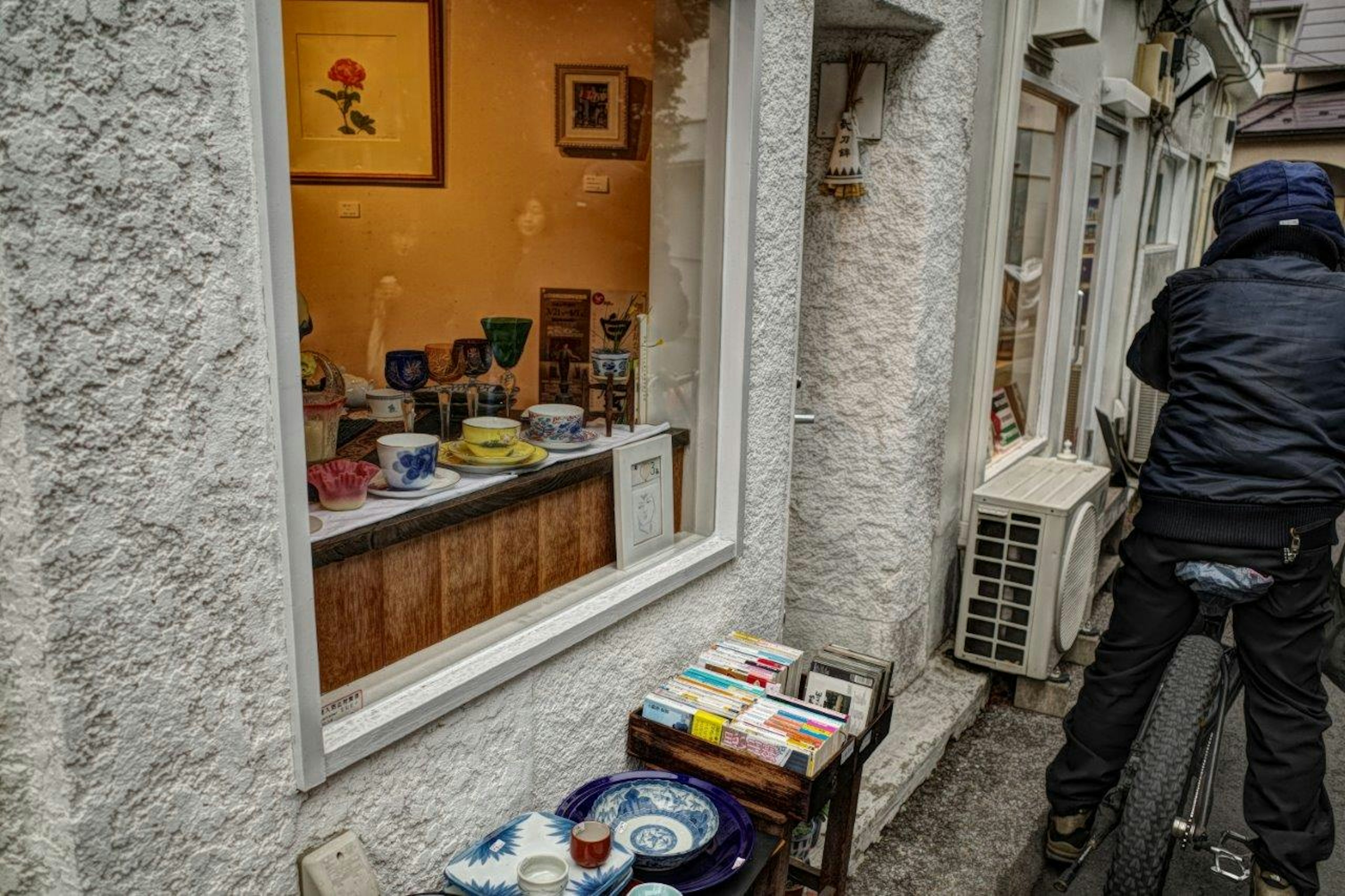 View through a window showcasing colorful dishes and goods inside a small shop