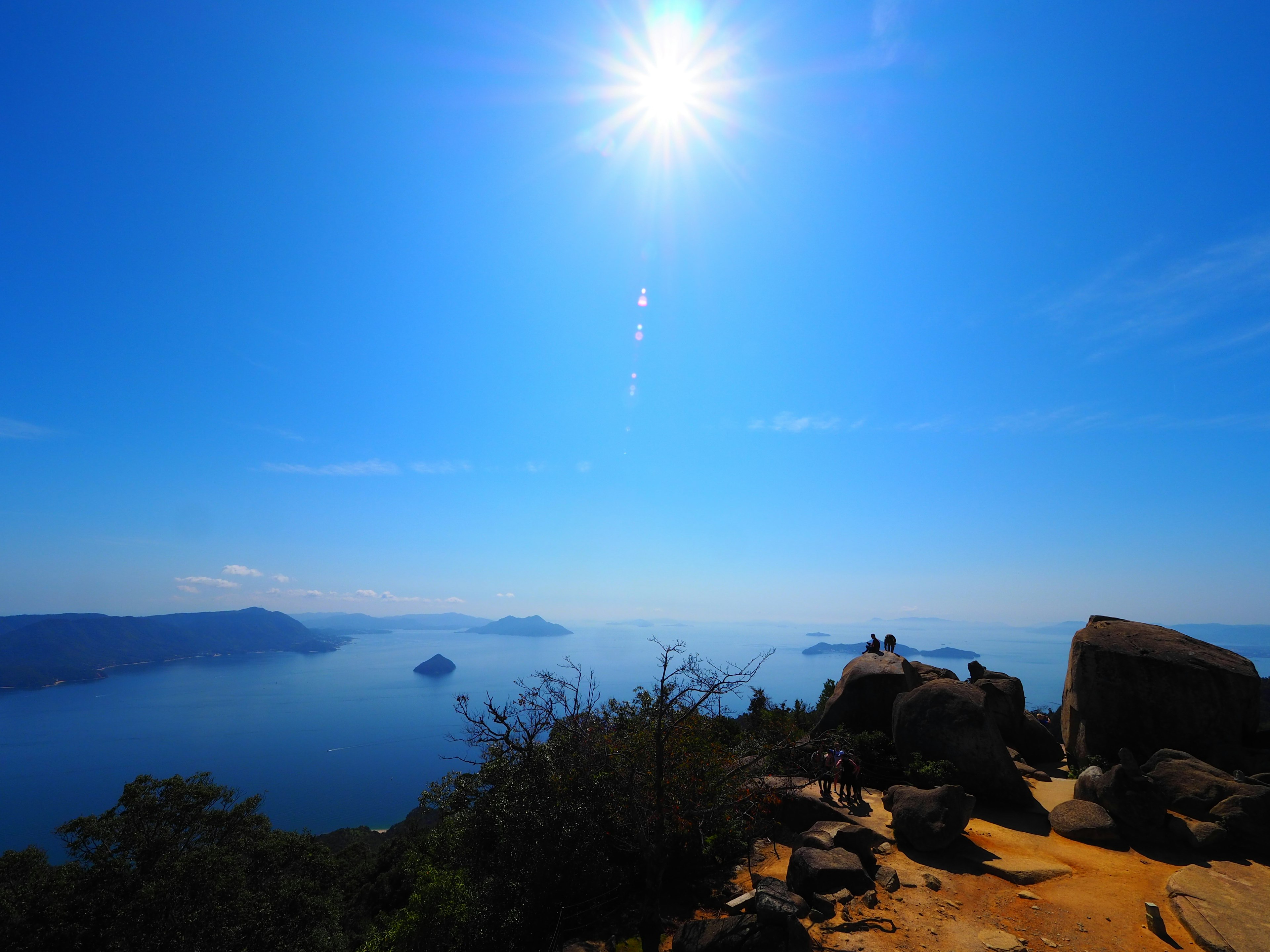 青い空と太陽が照らす海の絶景岩場