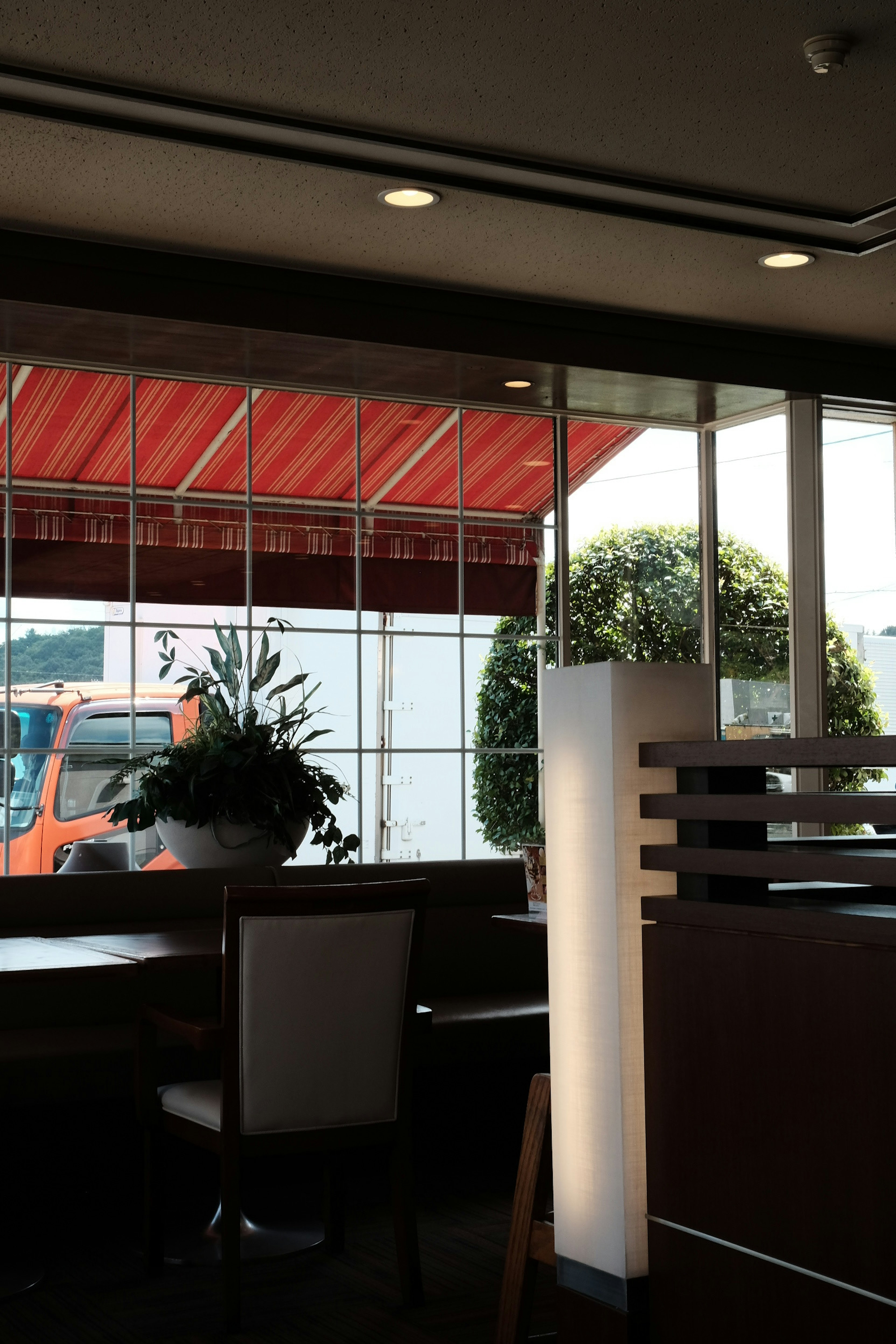 Interior view of a café showing plants and a truck outside