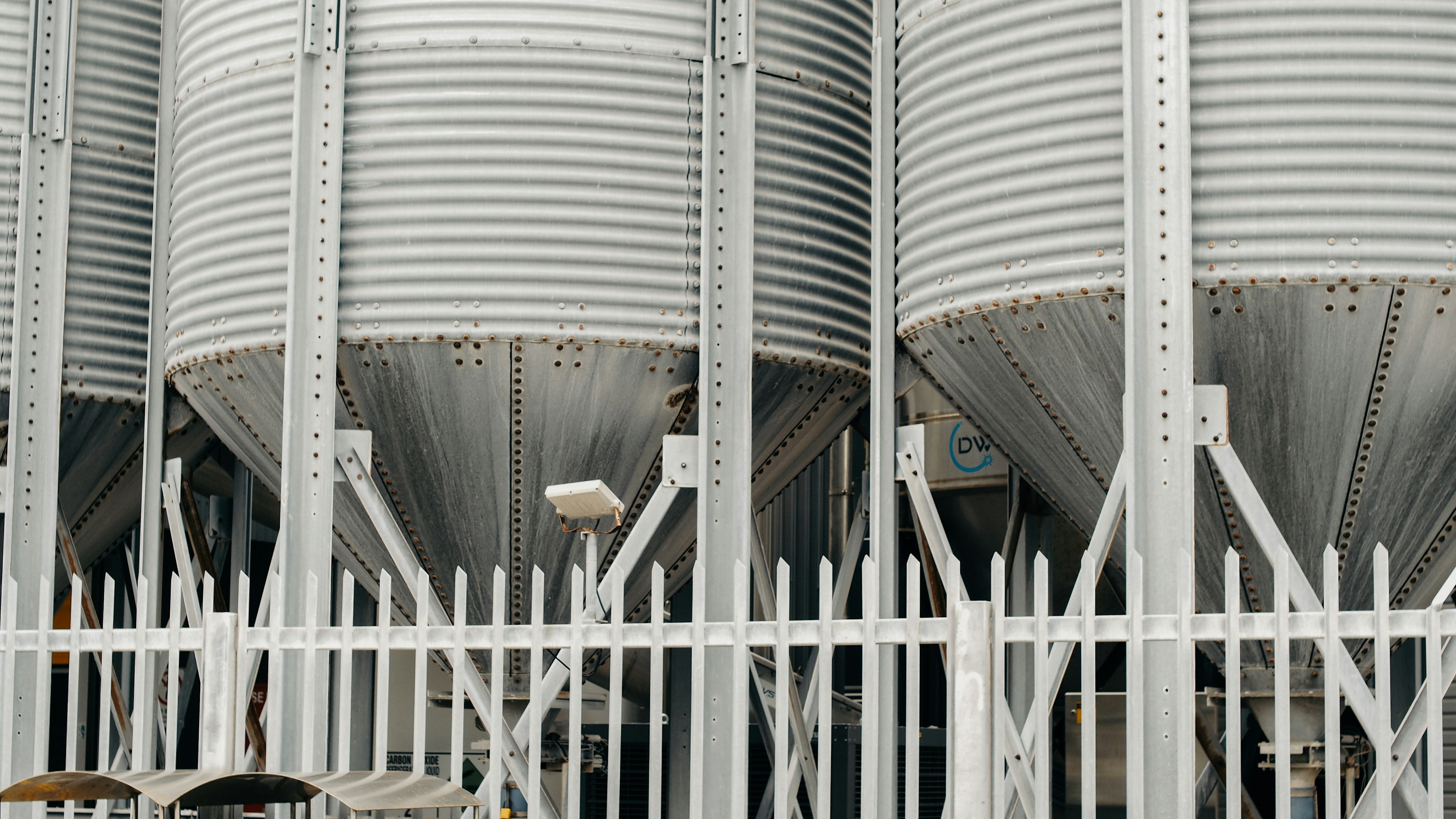 Row of silver cylindrical silos at a factory