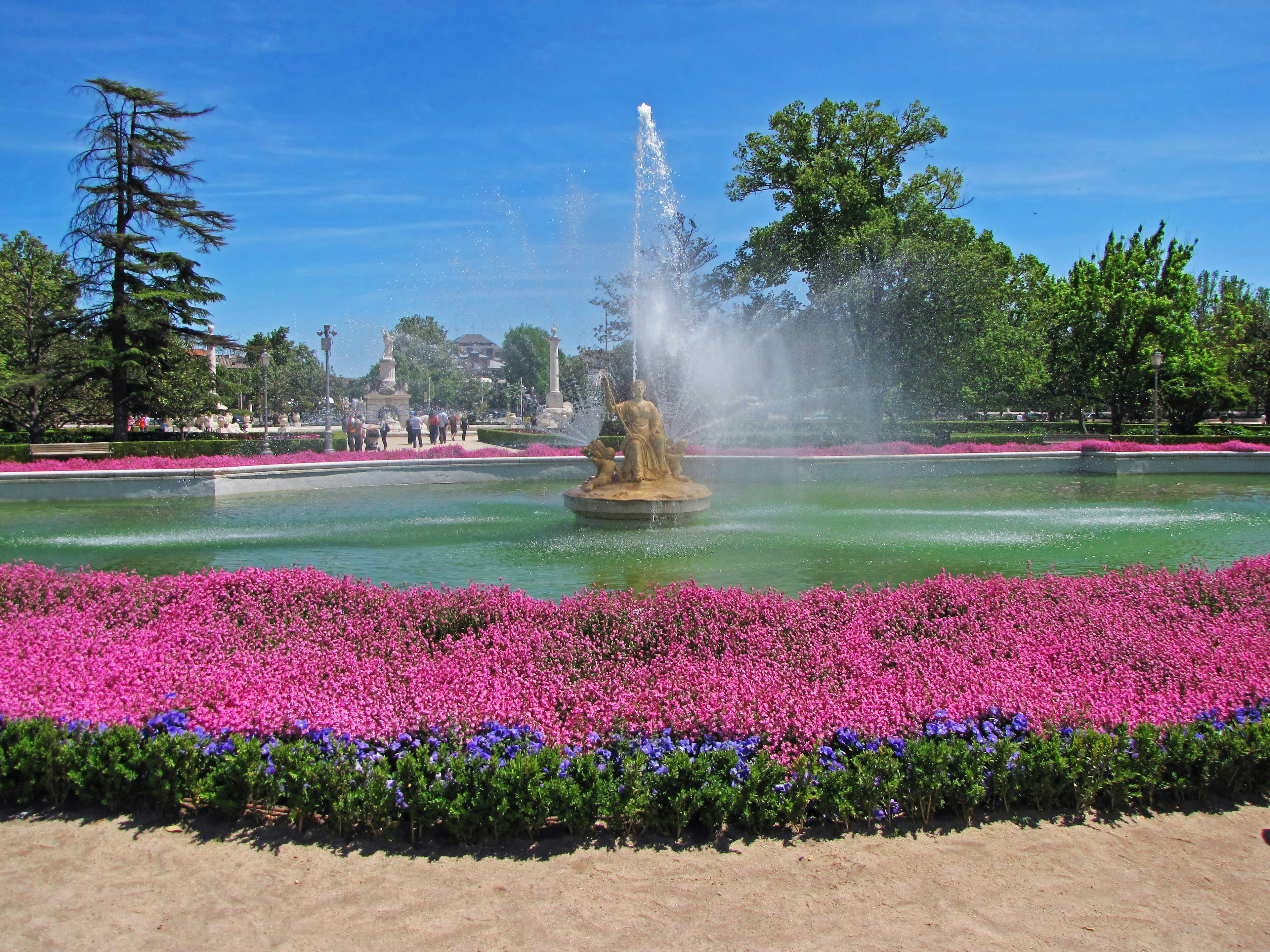 美しい公園の池にある噴水とカラフルな花々