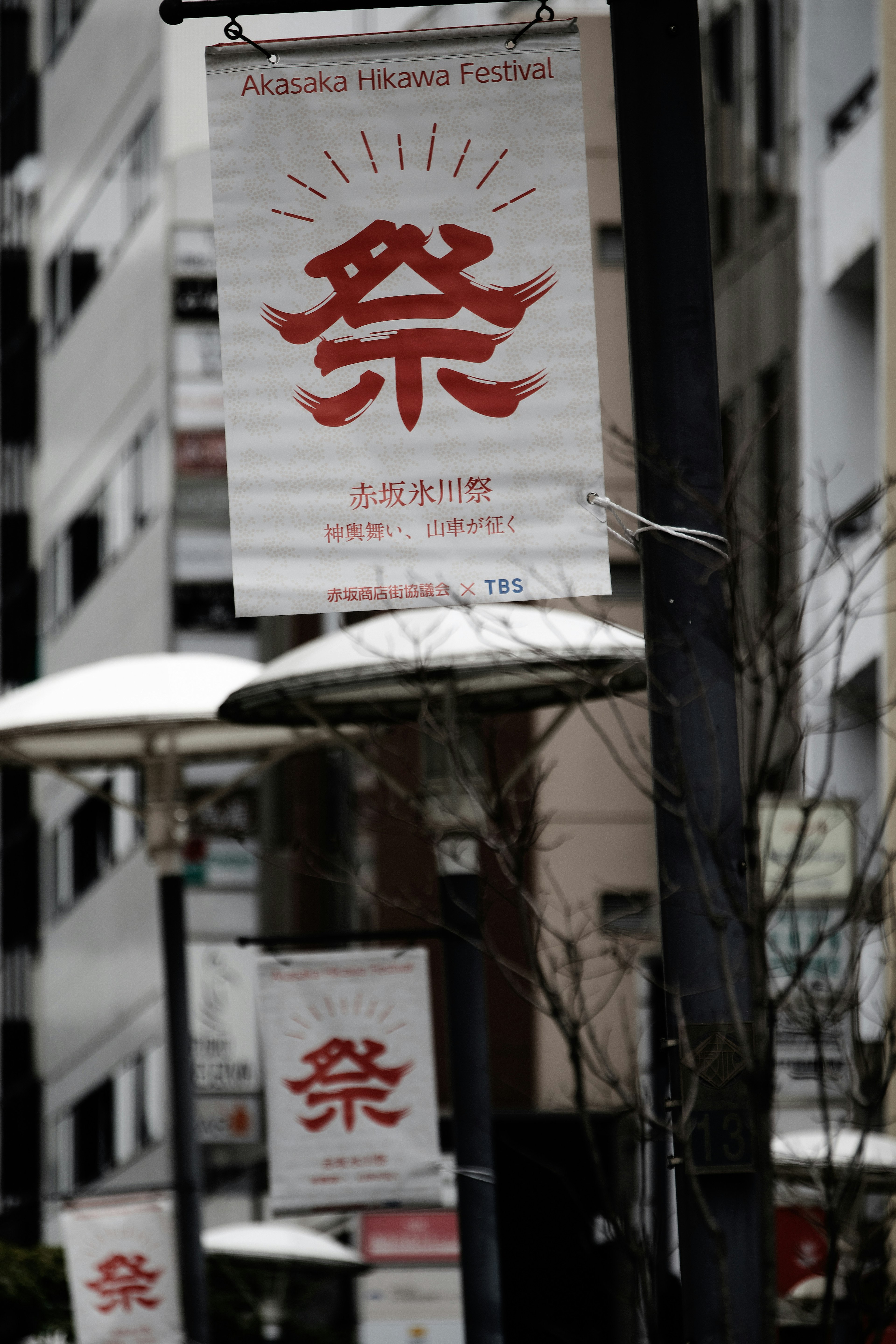 街中の祭りを告知する赤い文字の看板が並ぶ