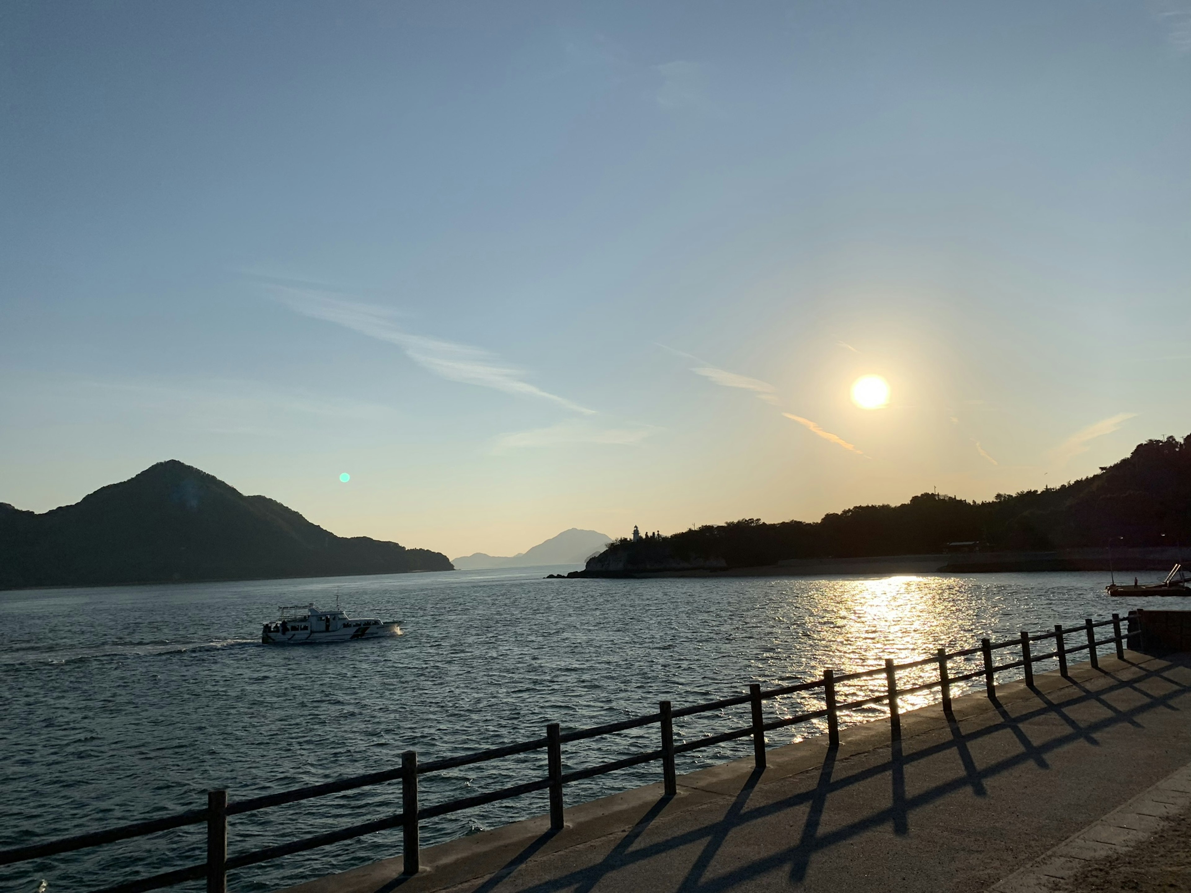 Vista panoramica di montagne e mare con un tramonto splendente lungo una costa calma