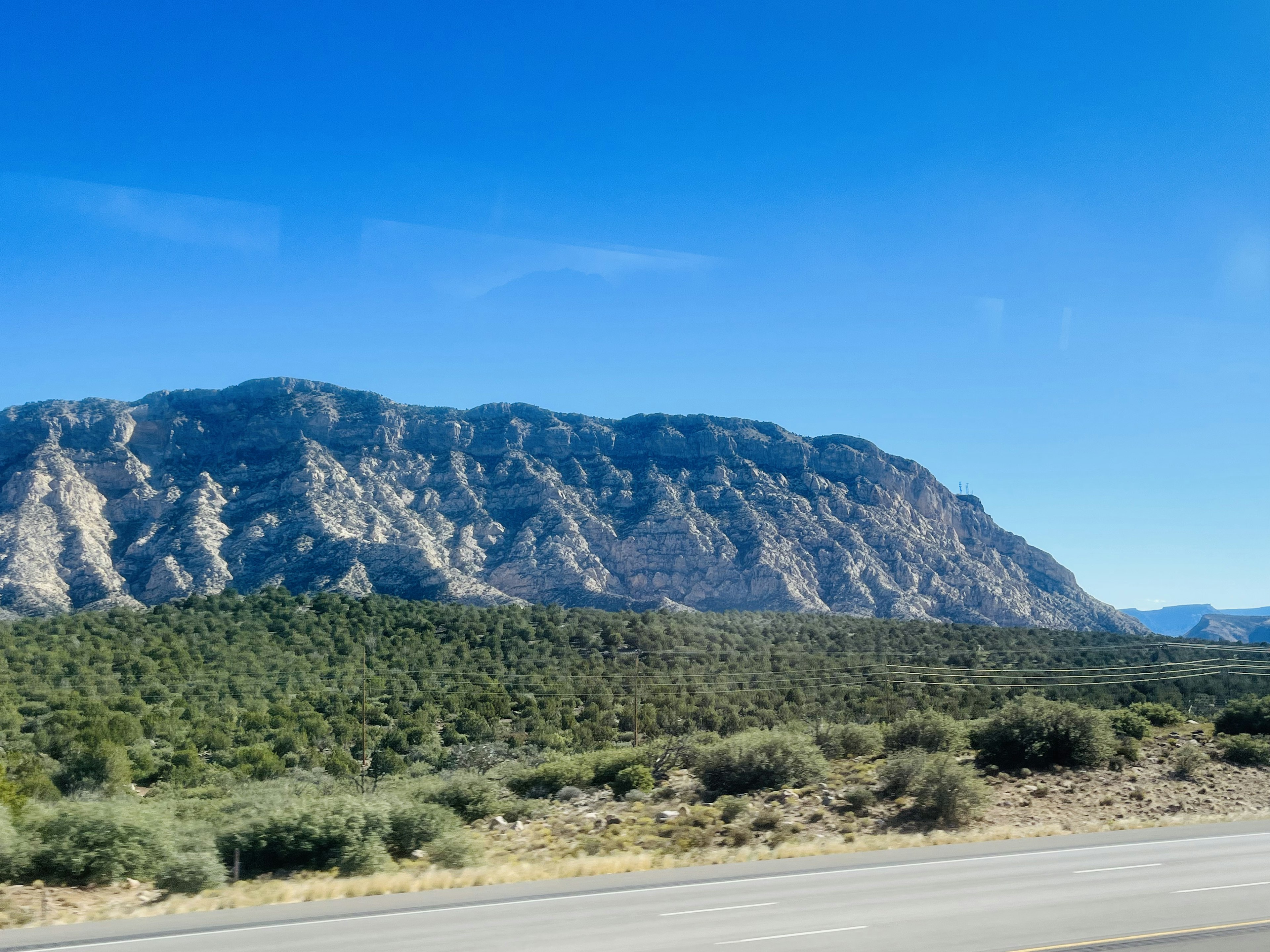 Panoramablick auf grüne Hügel und einen majestätischen Berg unter blauem Himmel