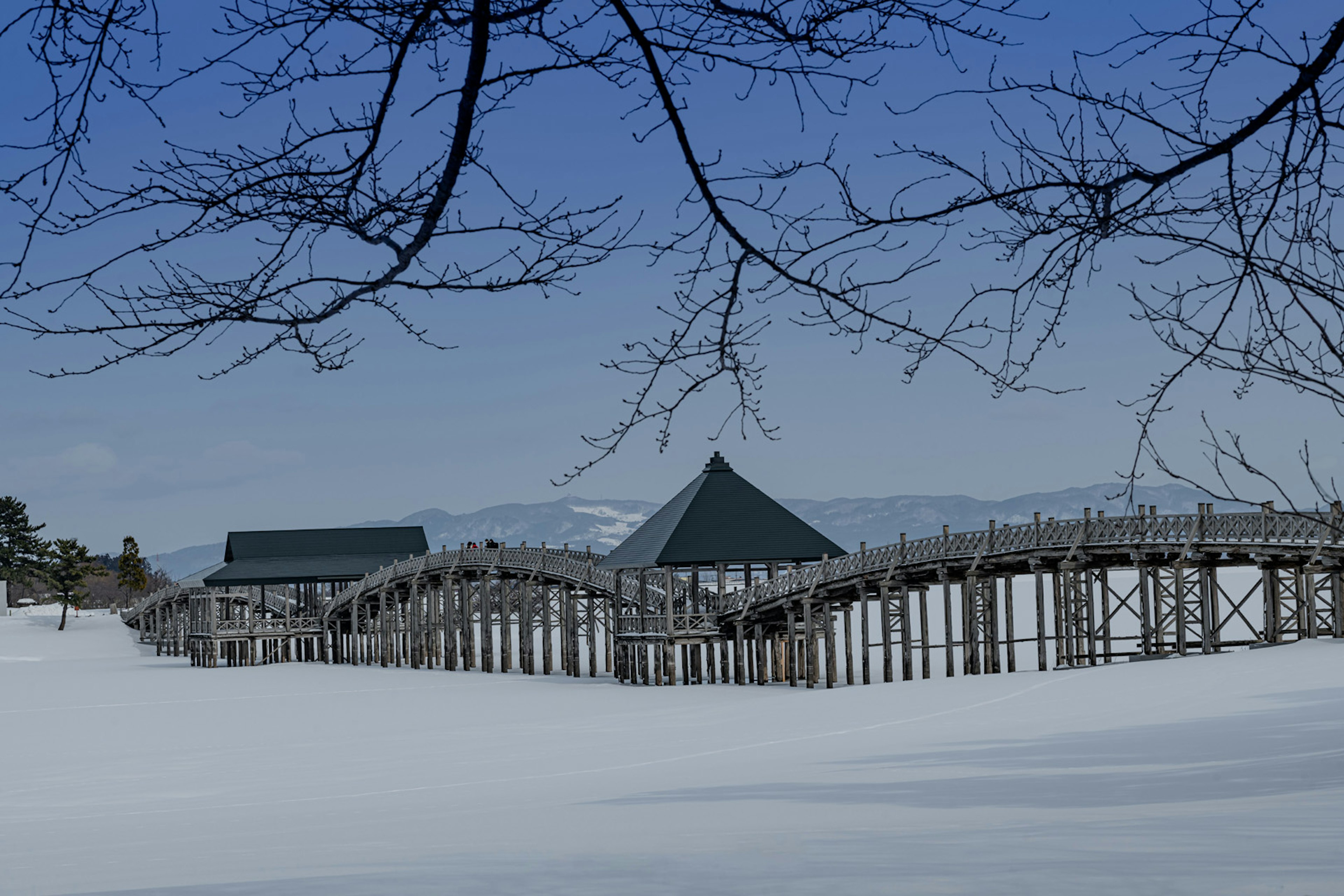 Wooden bridge and huts in a snow-covered landscape