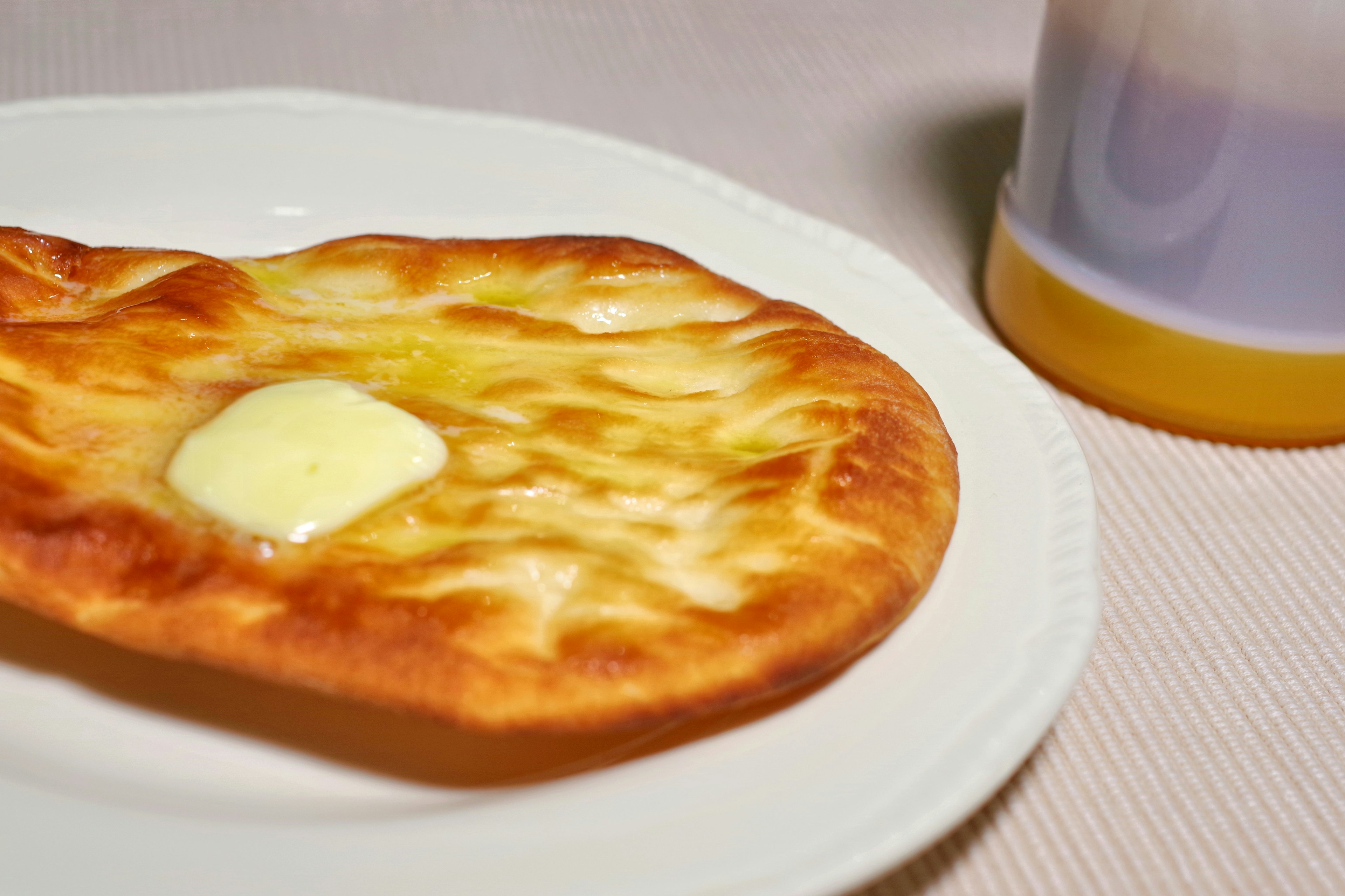 Pane piatto appena sfornato con burro su un piatto bianco