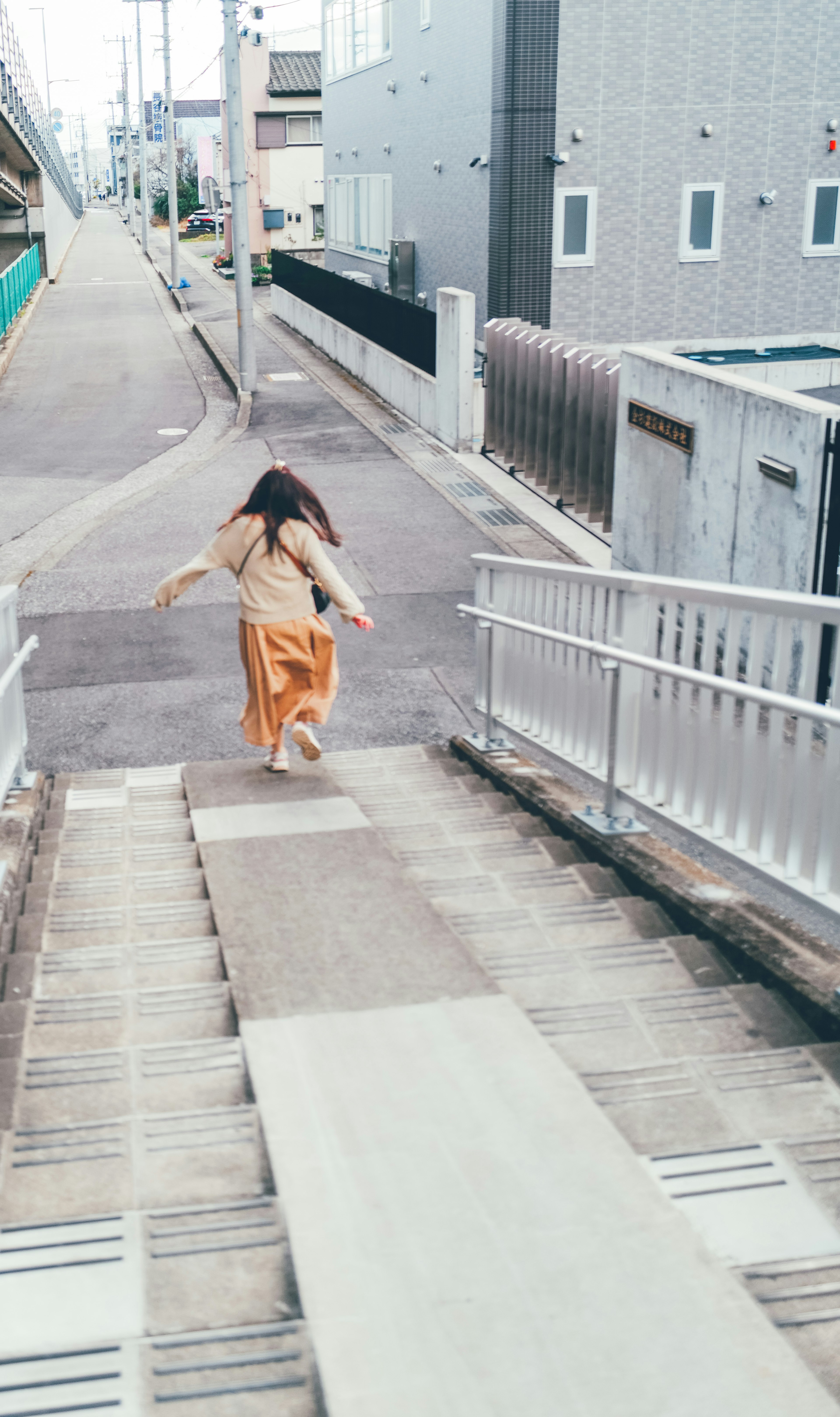 一名女性在城市環境中跑下樓梯