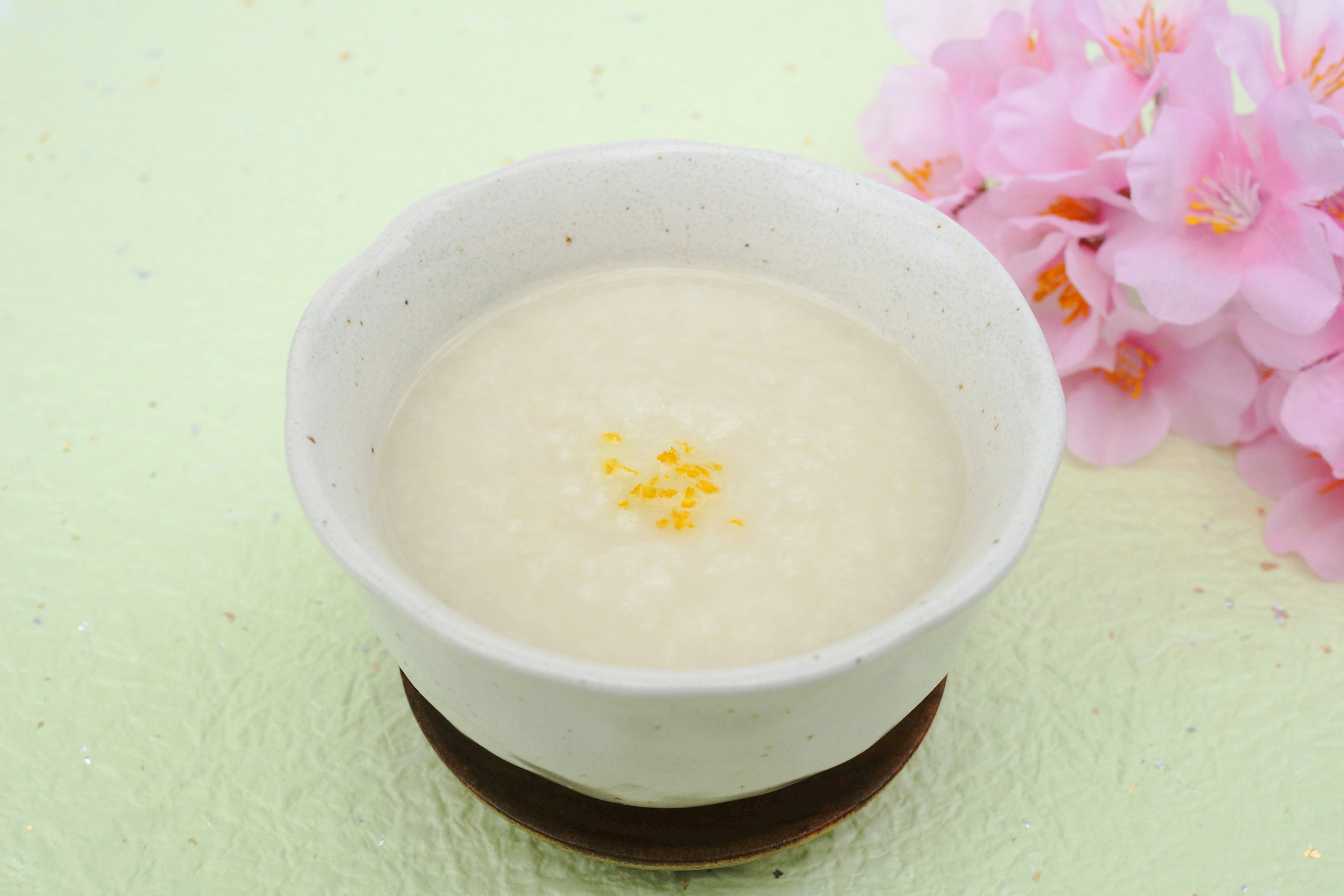 Sopa cremosa servida en un tazón blanco decorada con cáscara de limón