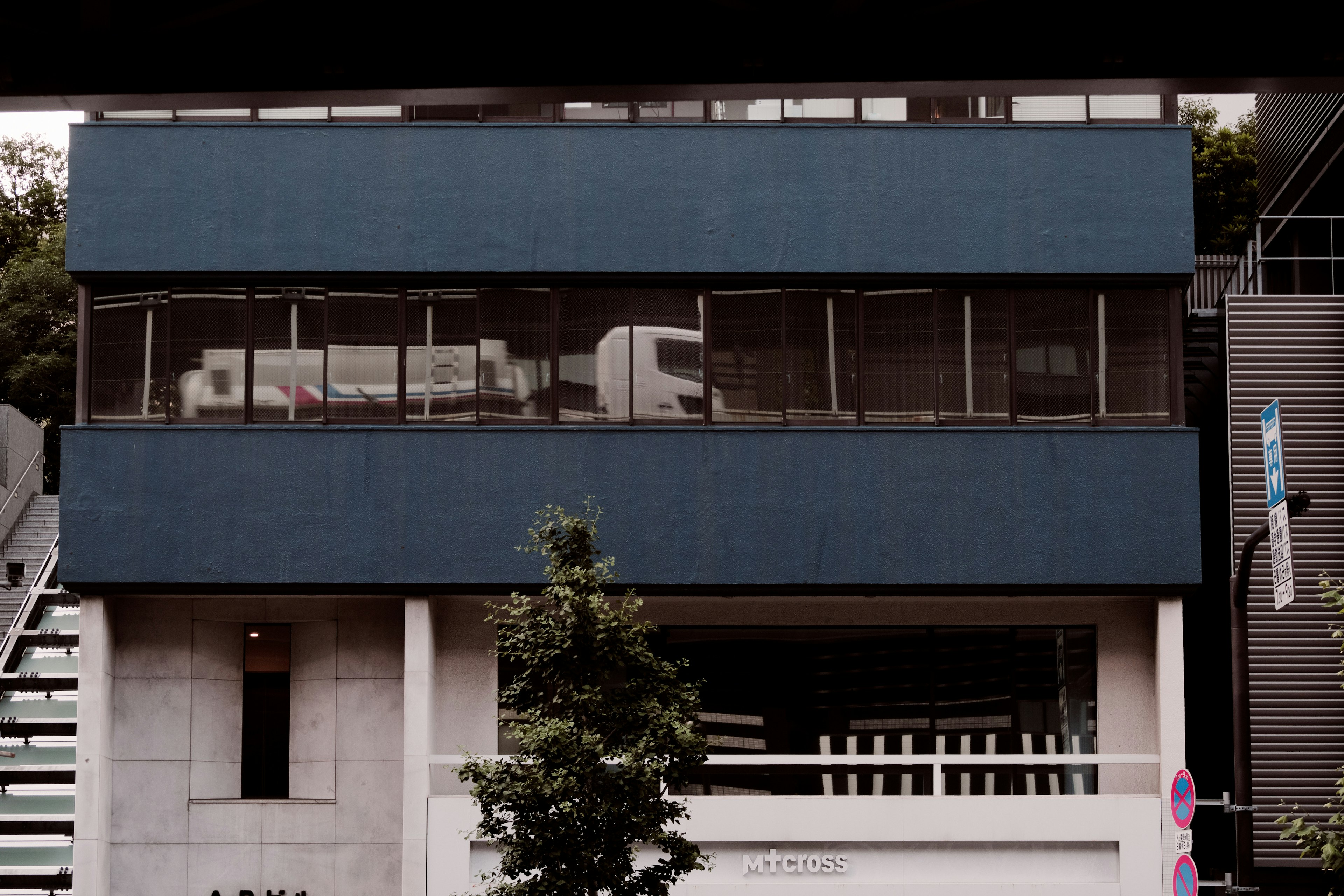 Bâtiment moderne avec façade bleue et arbre vert