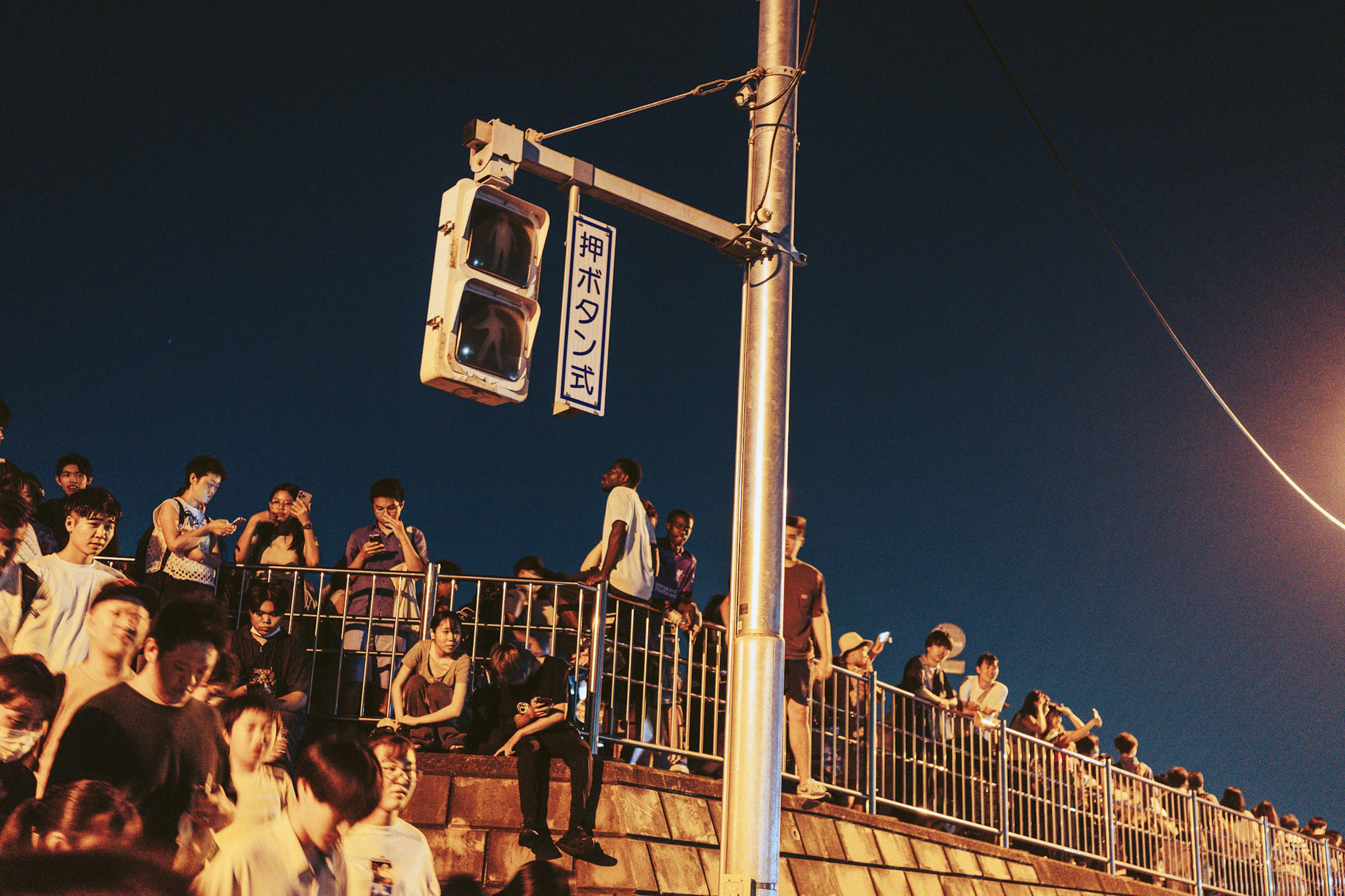 Semáforo y multitud de personas reunidas de noche con fondo urbano